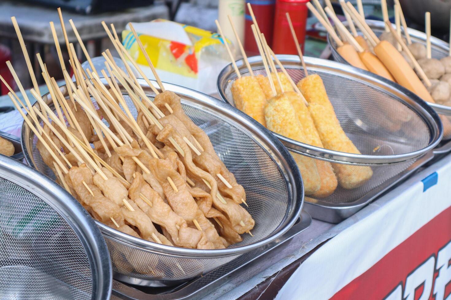 The tofu is cut thinly and skewered using bamboo, then fried and sold at culinary festivals photo