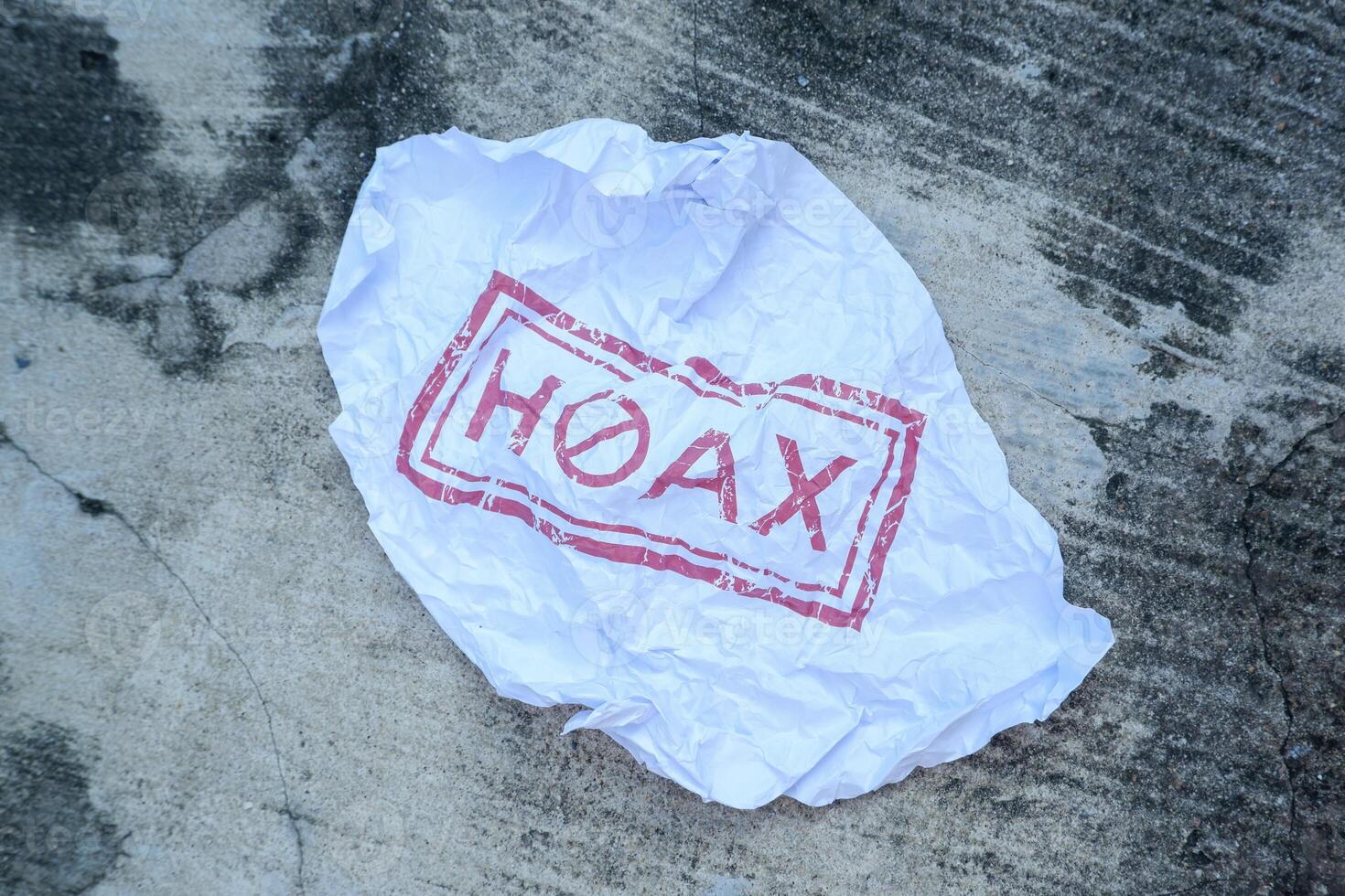 crumpled paper with hoax writing in red. illustration concept of stop giving false or fake news photo