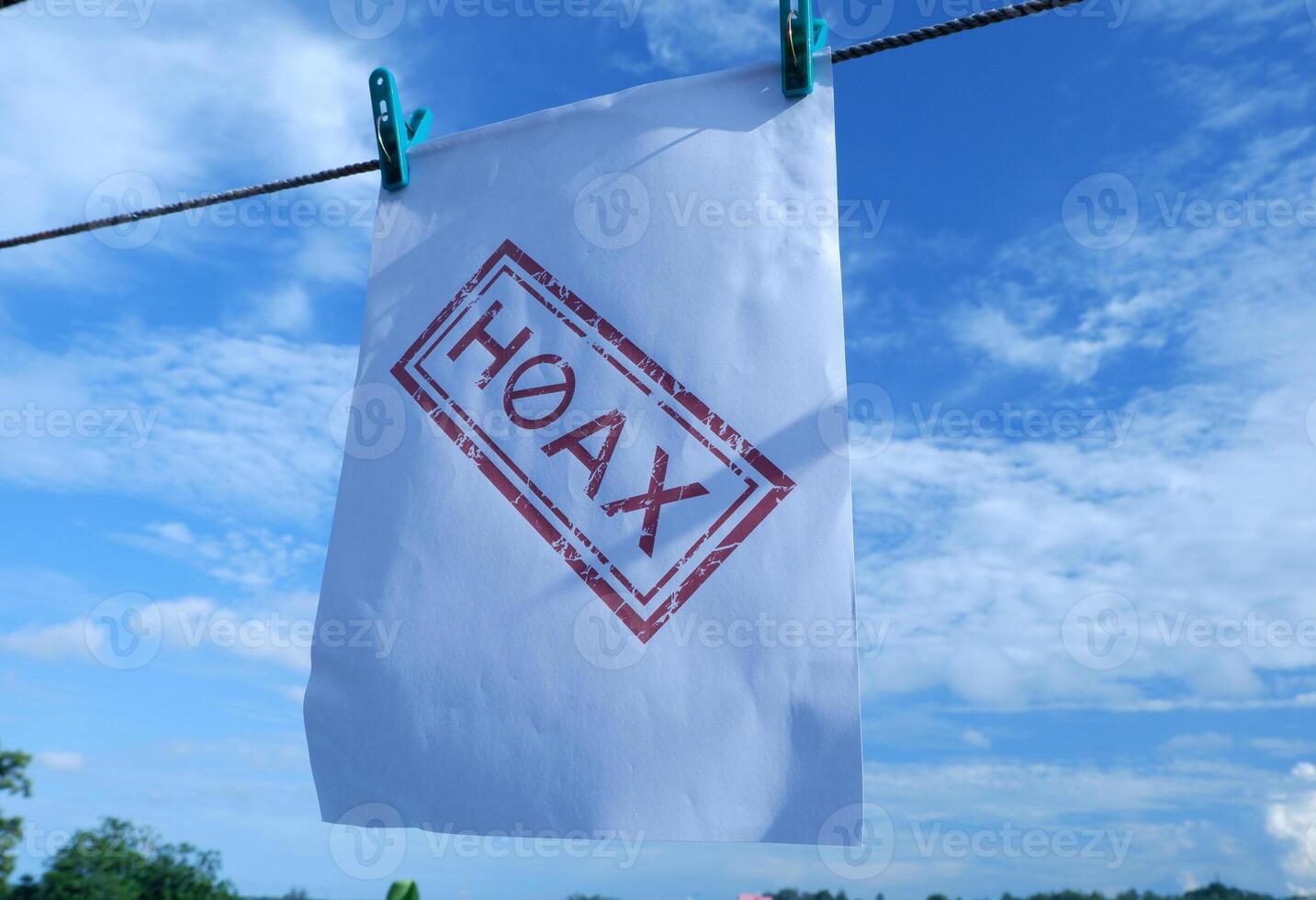 white paper hanging with red hoax writing. illustration concept of stop giving false or fake news photo