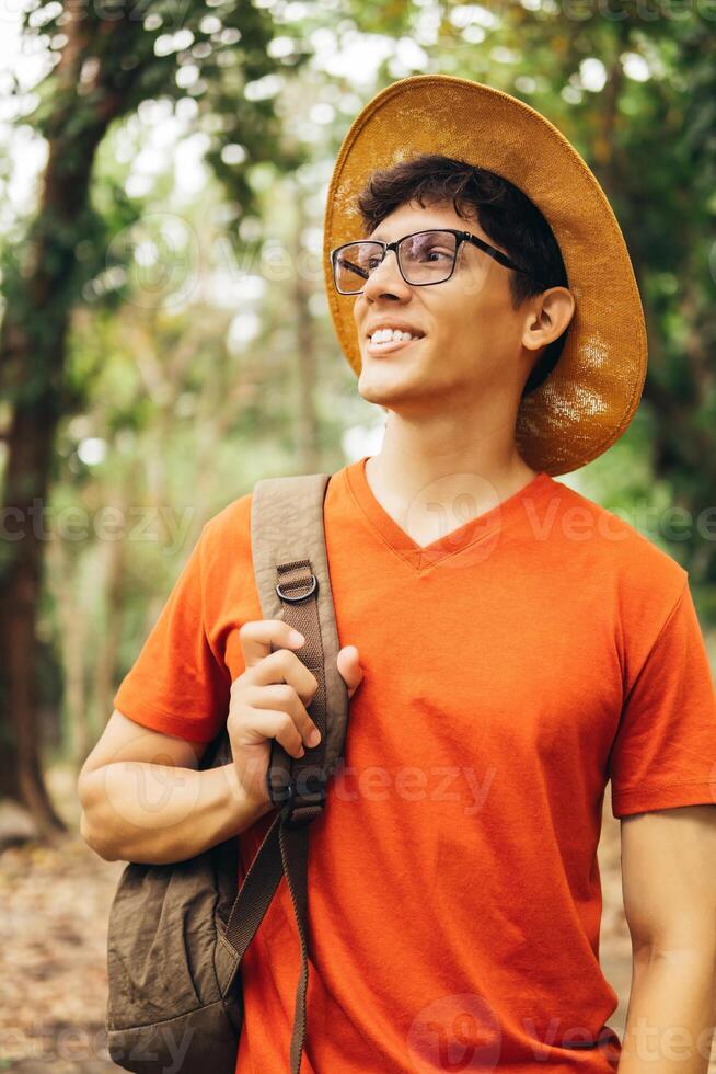 Portrait of latin american man with hat and backpack in eyeglasses for good vision looking away. photo