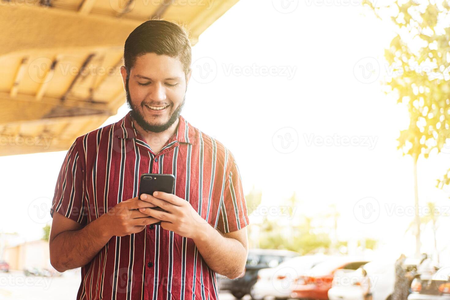 Young latin american man using a mobile phone. photo