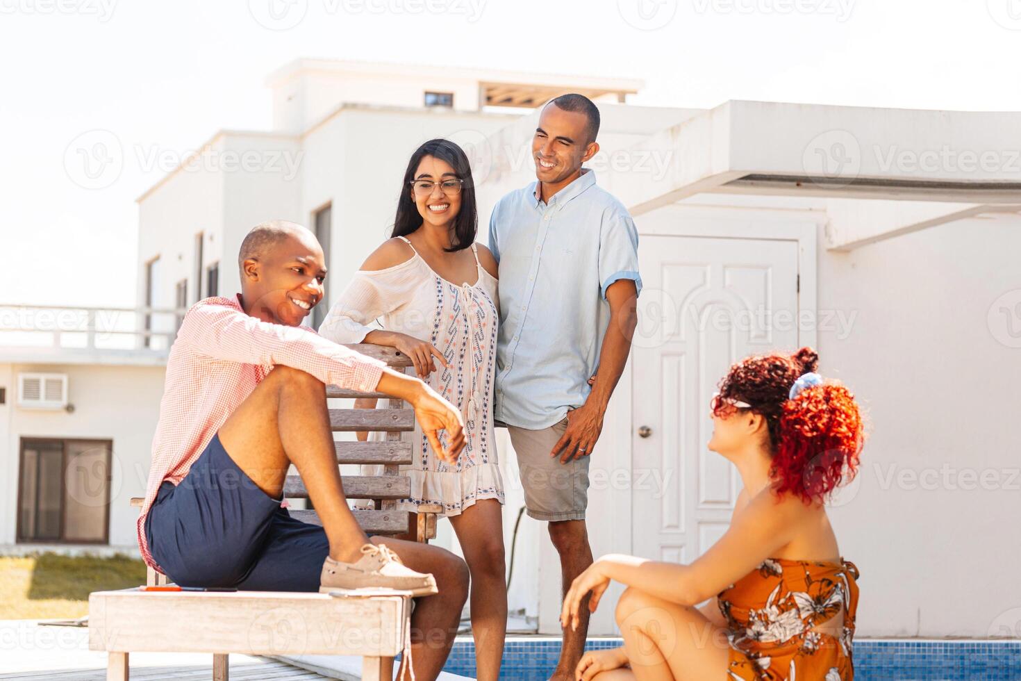 Group of four friends talking in the pool. photo