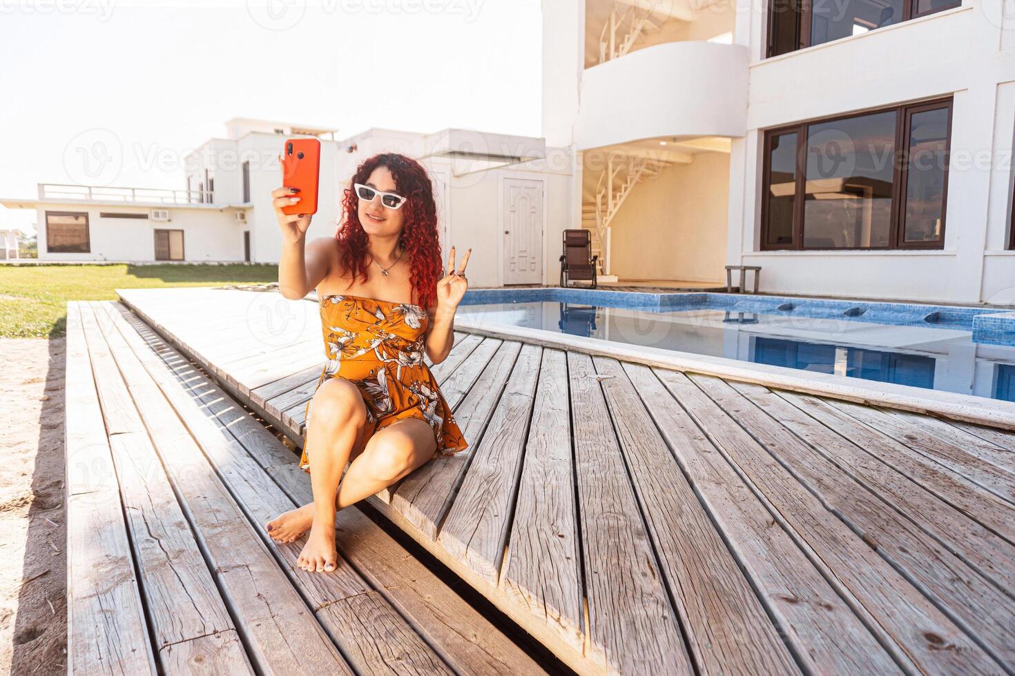 woman taking a selfie behind a pool. photo