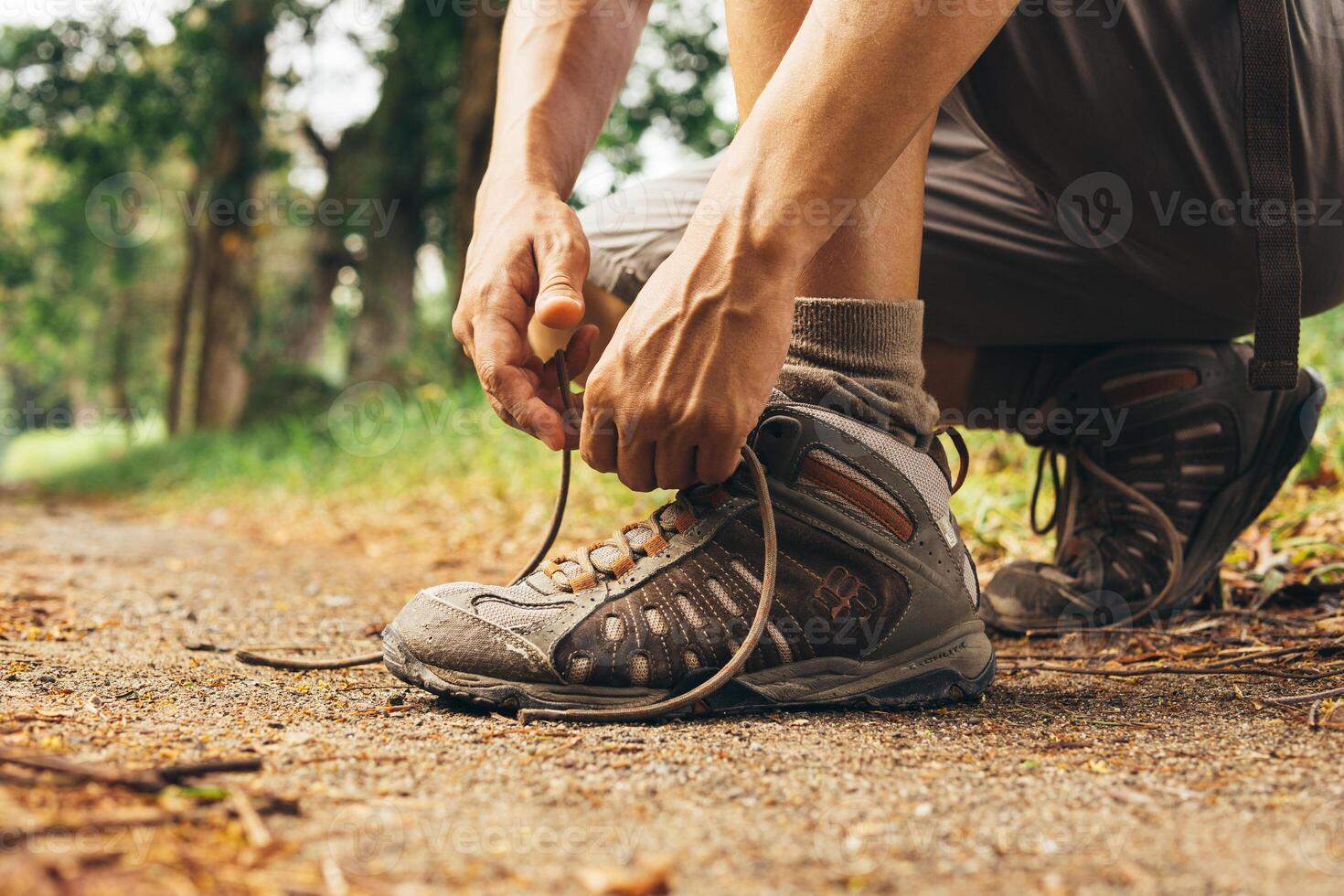Hiker tying shoe laces in the mountain photo