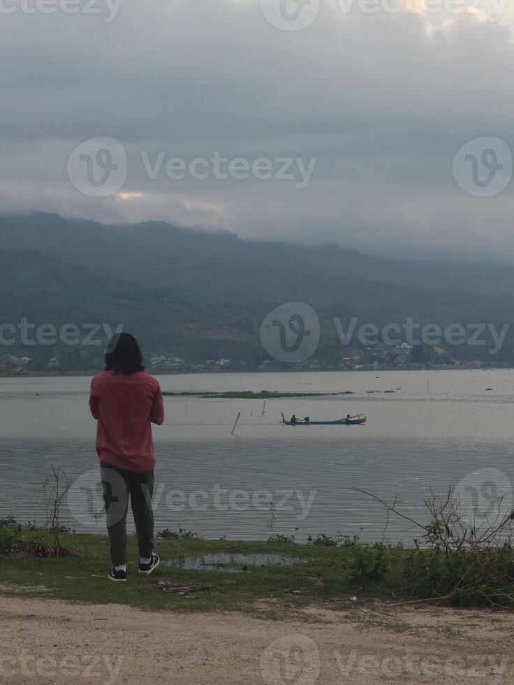 A Man Enjoys the Evening Atmosphere on the Edge of Lake Limboto, Gorontalo photo