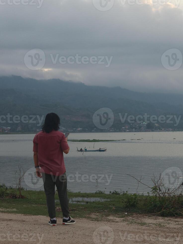 A Man Enjoys the Evening Atmosphere on the Edge of Lake Limboto, Gorontalo photo