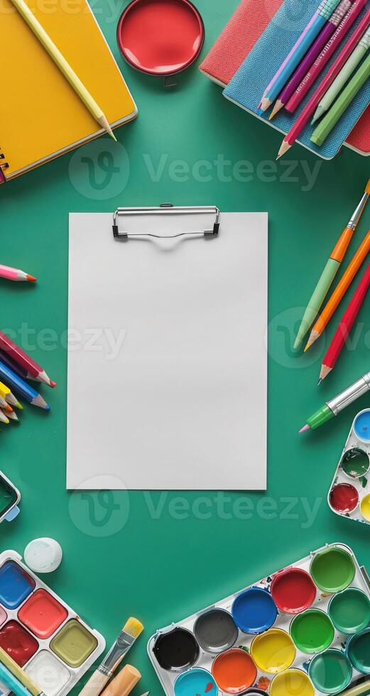 School vertical green background with pen, pencil, notepad, book, paints, crayons. Stationery around empty space. Back to School Advertising photo