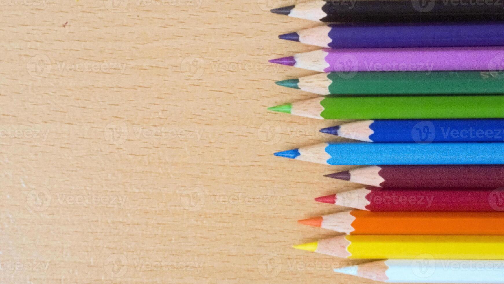 color pencils in light wood texture background photo