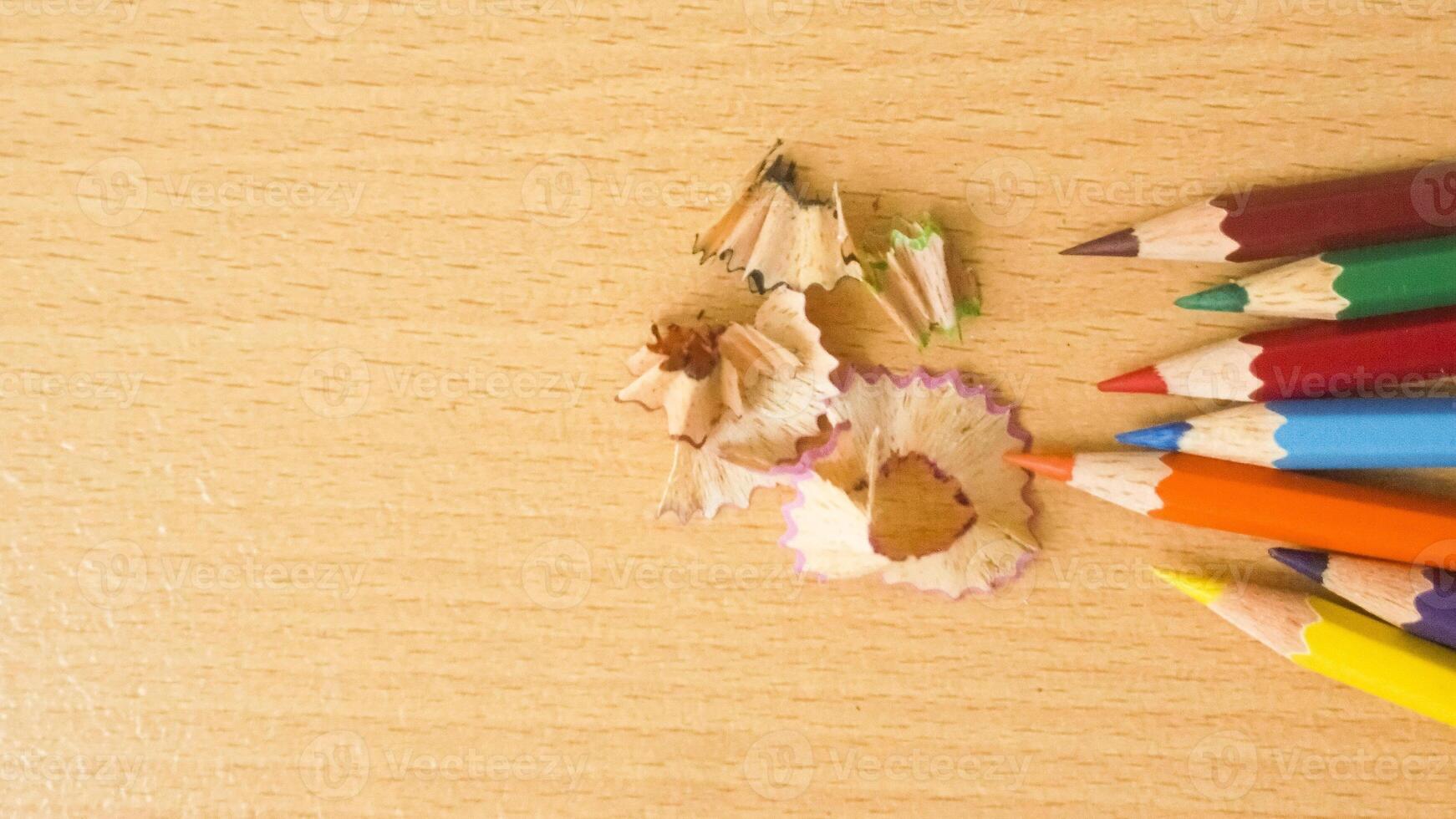 color pencils in light wood texture background photo