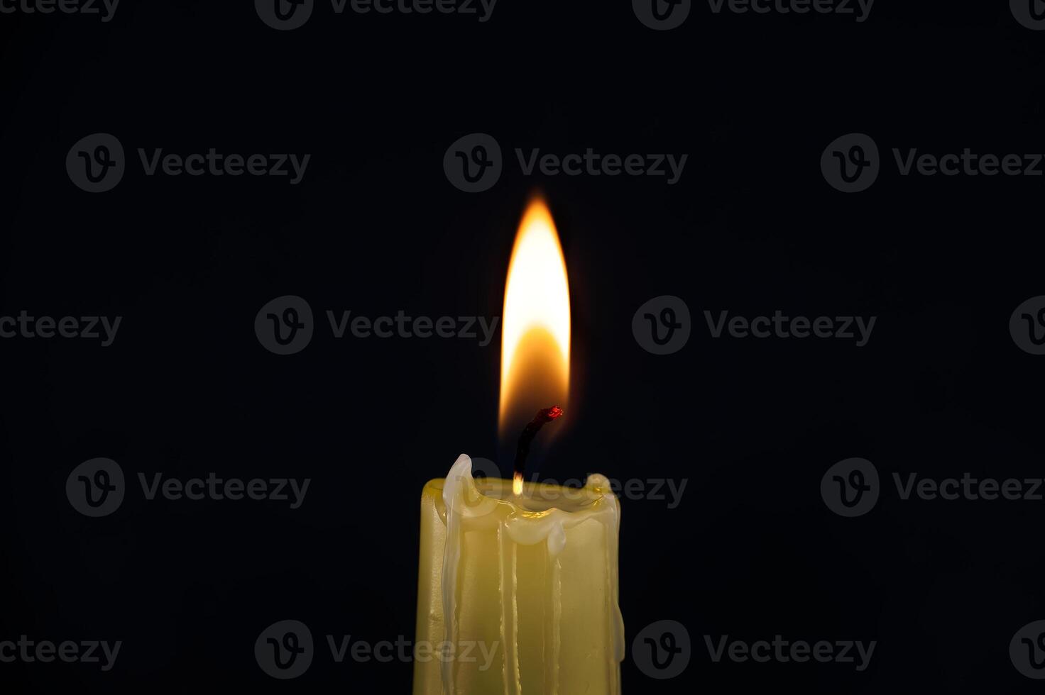 Single burning candle over black background photo