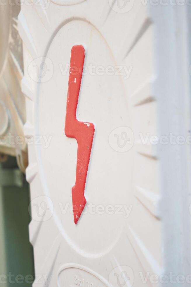 Two electrical boxes with lightning bolt on brick wall photo
