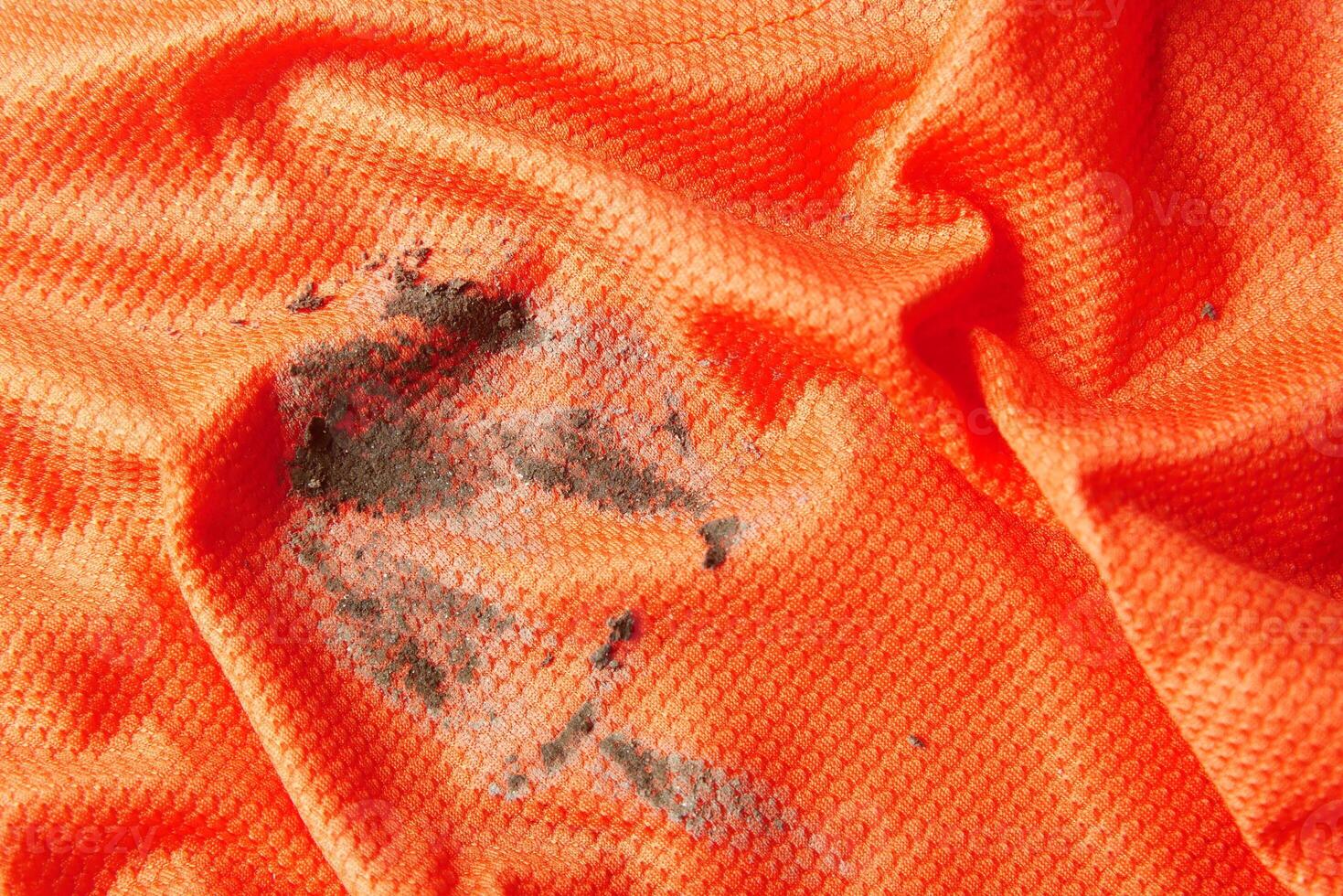 dirty mud stain on a orange color cloth photo