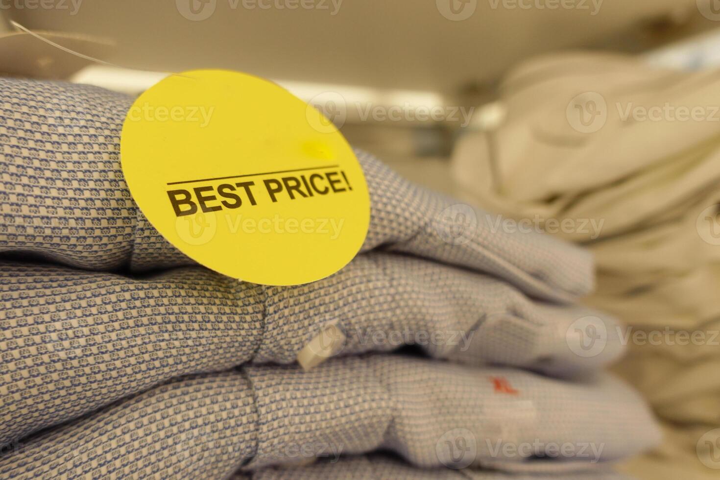 A neat stack of folded shirts with yellow price tags, a bargain at the clothing store photo