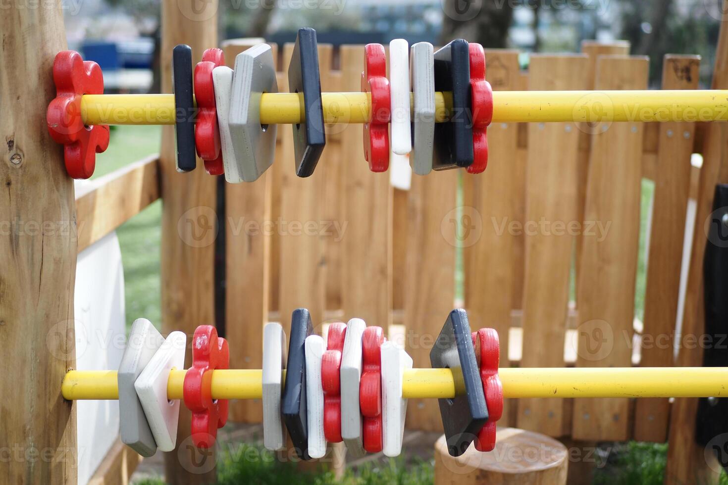 a wooden toy with red white and black squares and yellow sticks photo