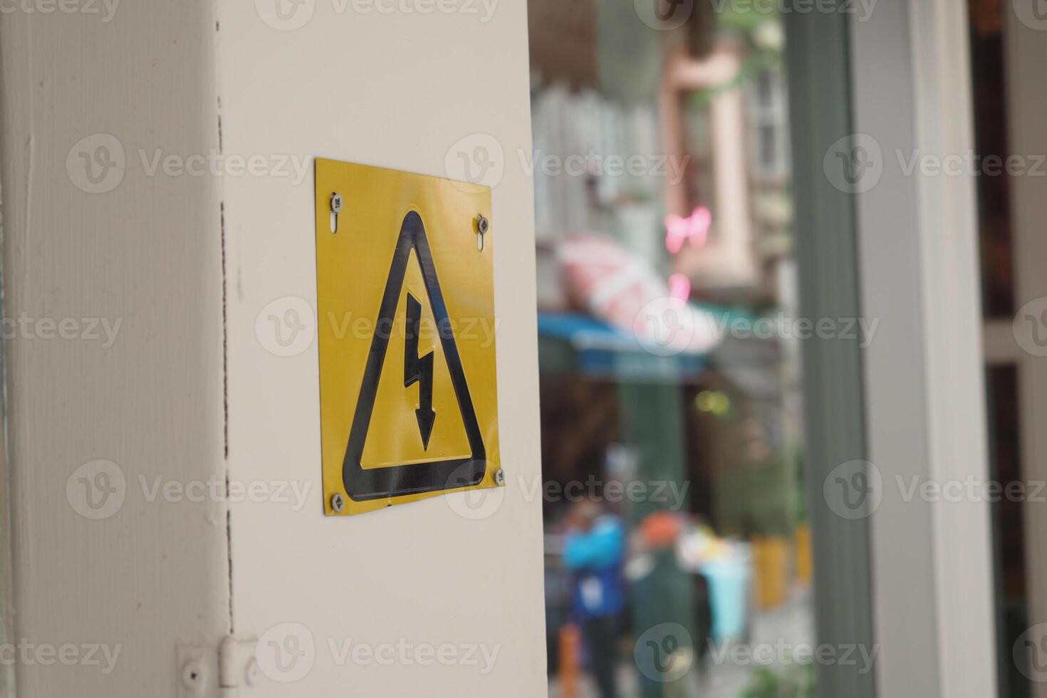 Two electrical boxes with lightning bolt on brick wall photo