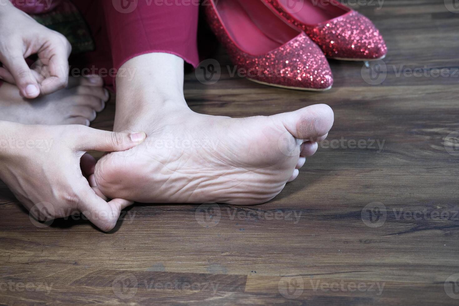 women sitting on floor feeling pain on feet photo