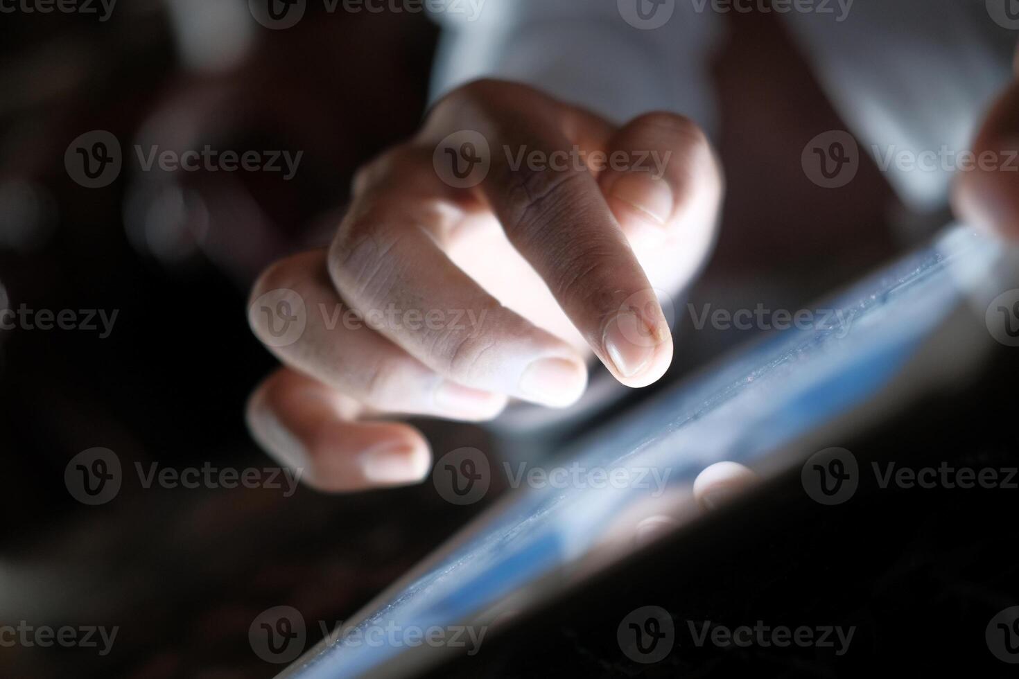 Close up of man hand using digital tablet at night. photo