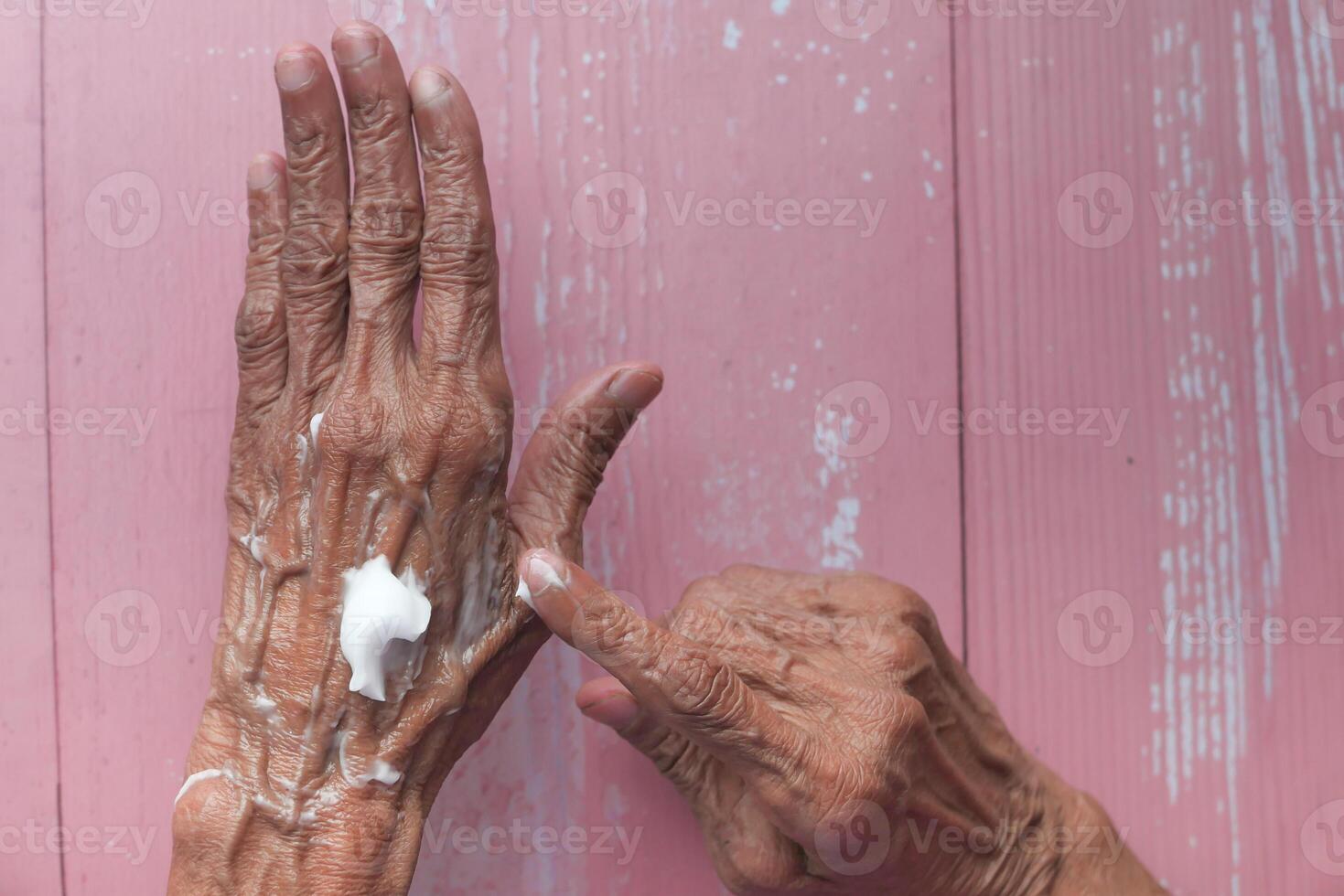 Senior woman applying hand cream, closeup. photo