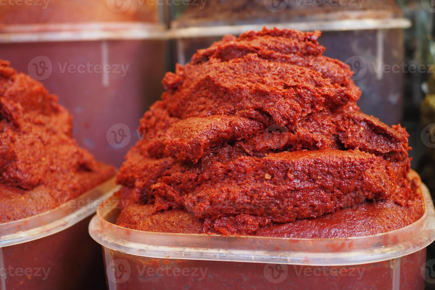 Observing the detailed view of containers filled with Red Pepper Paste available at a local market photo