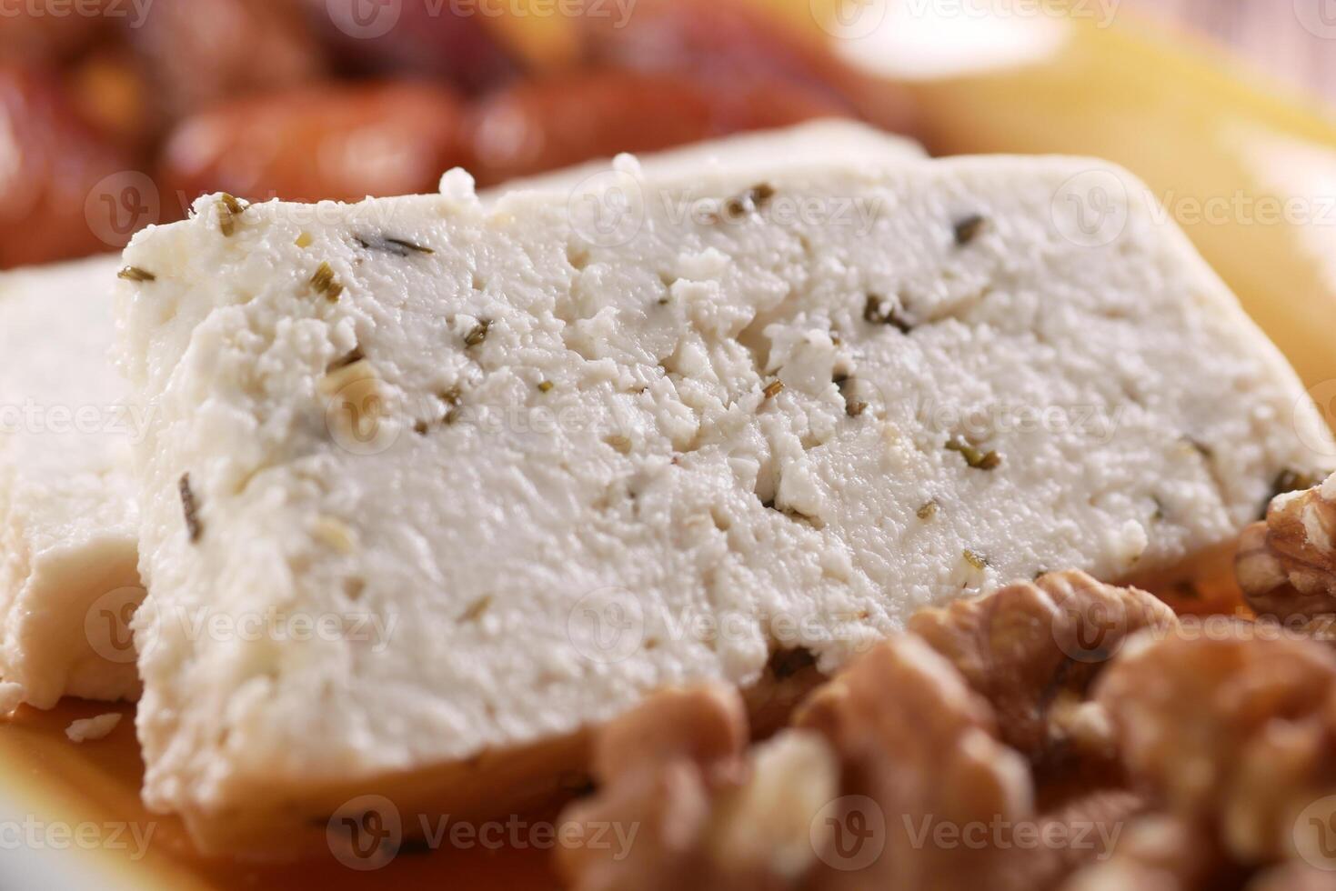 A detailed view of freshly served feta cheese complemented with walnuts on a plate photo