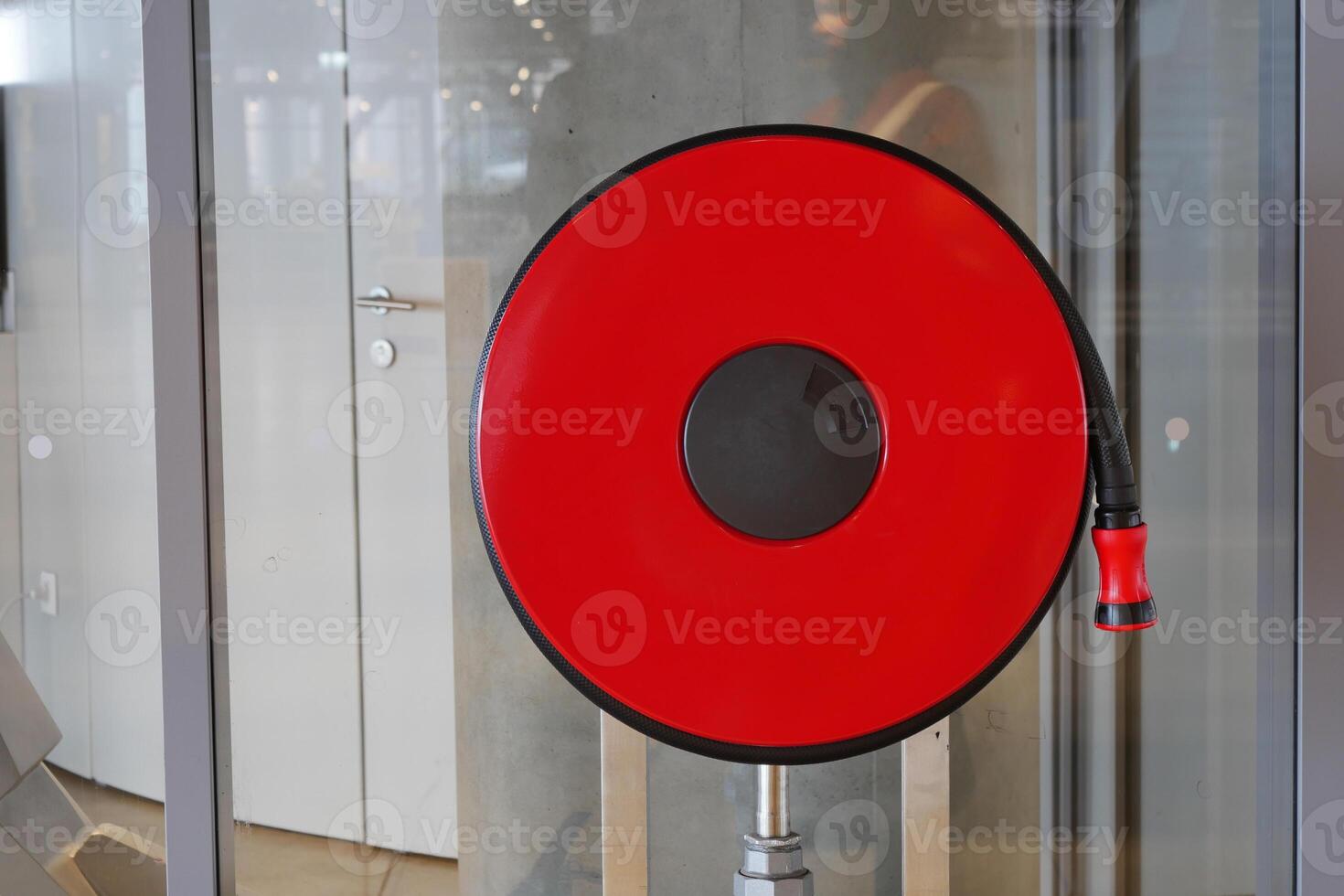 A red fire hose reel is installed in a modern building, emphasizing safety and emergency readiness photo