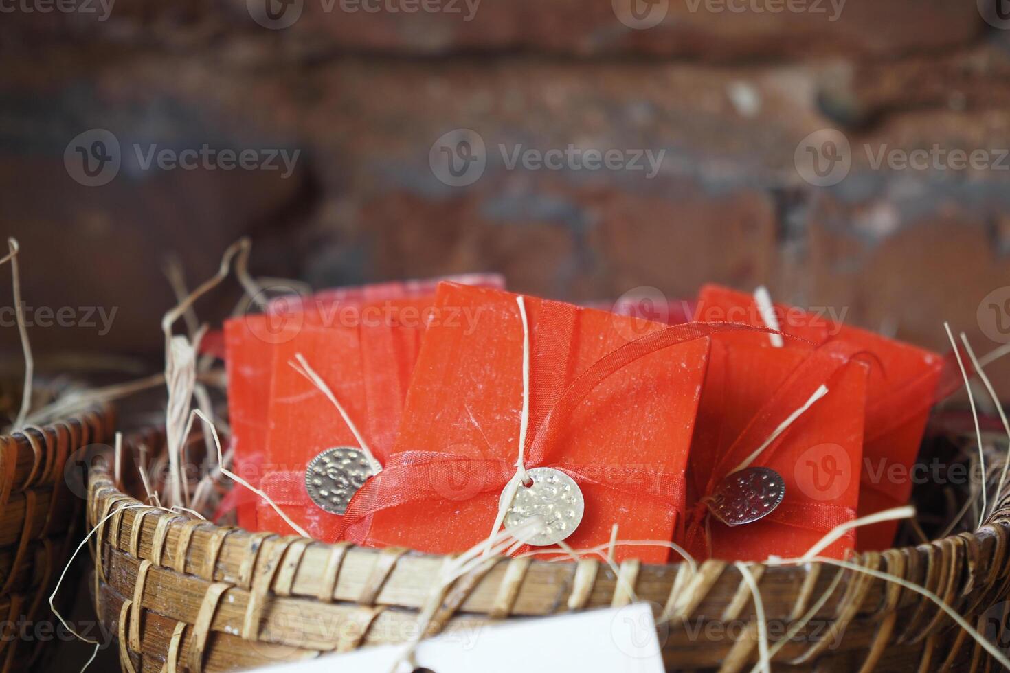 A stack of red color soaps with ribbons in a basket photo