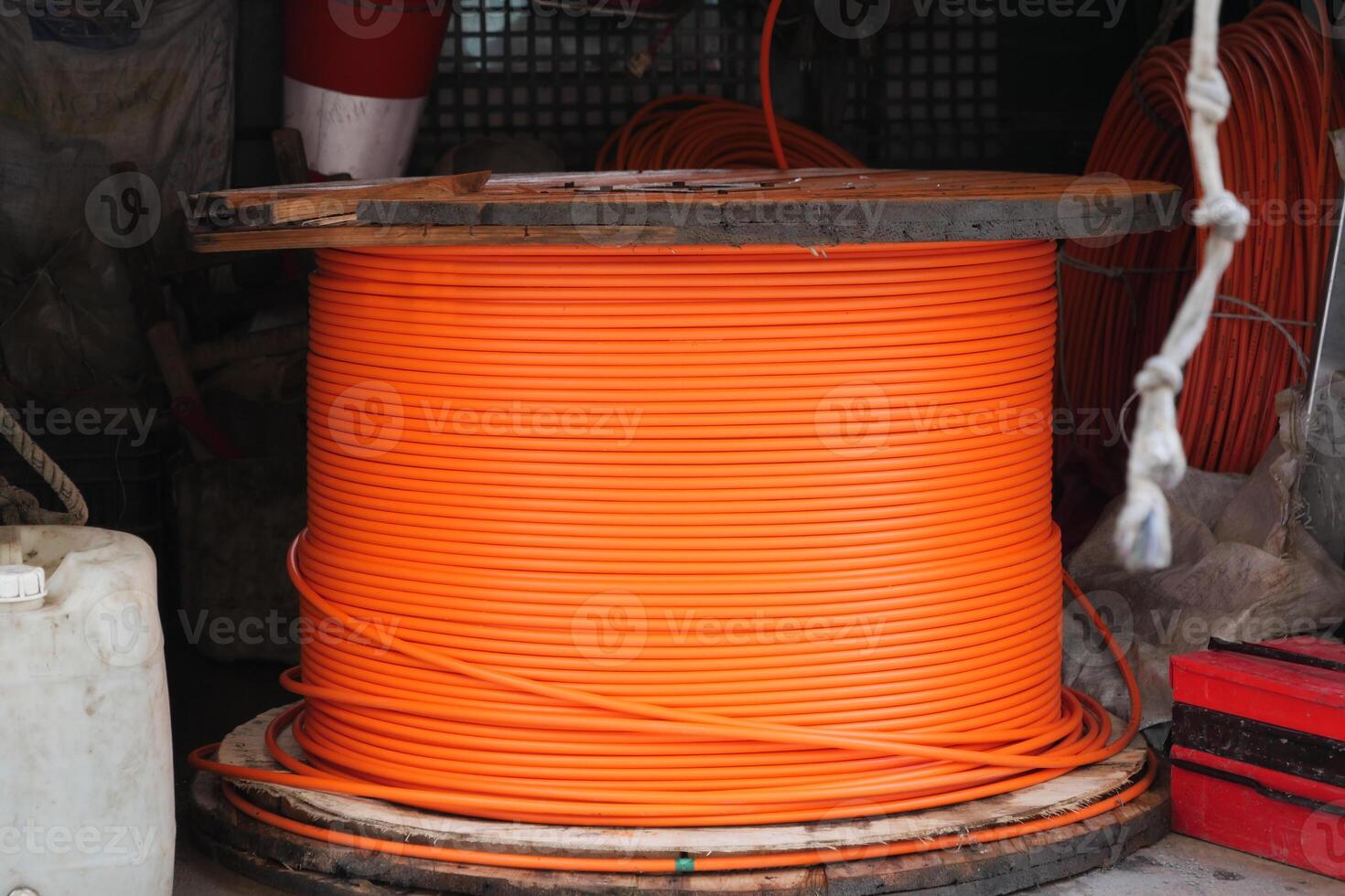 A large orange cable reel is kept in a warehouse for construction and maintenance photo