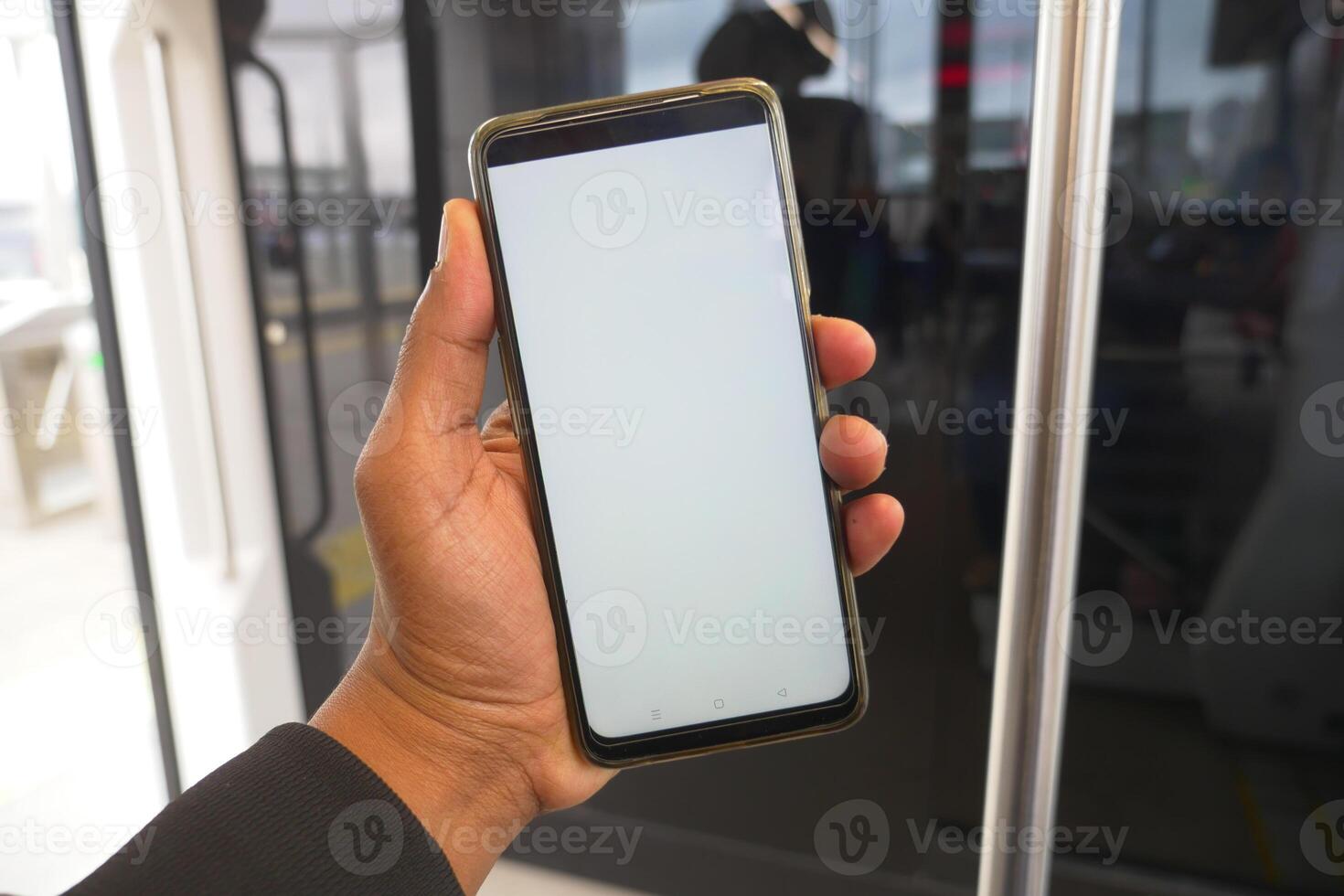young man hand using smart phone with green screen inside of metro train photo