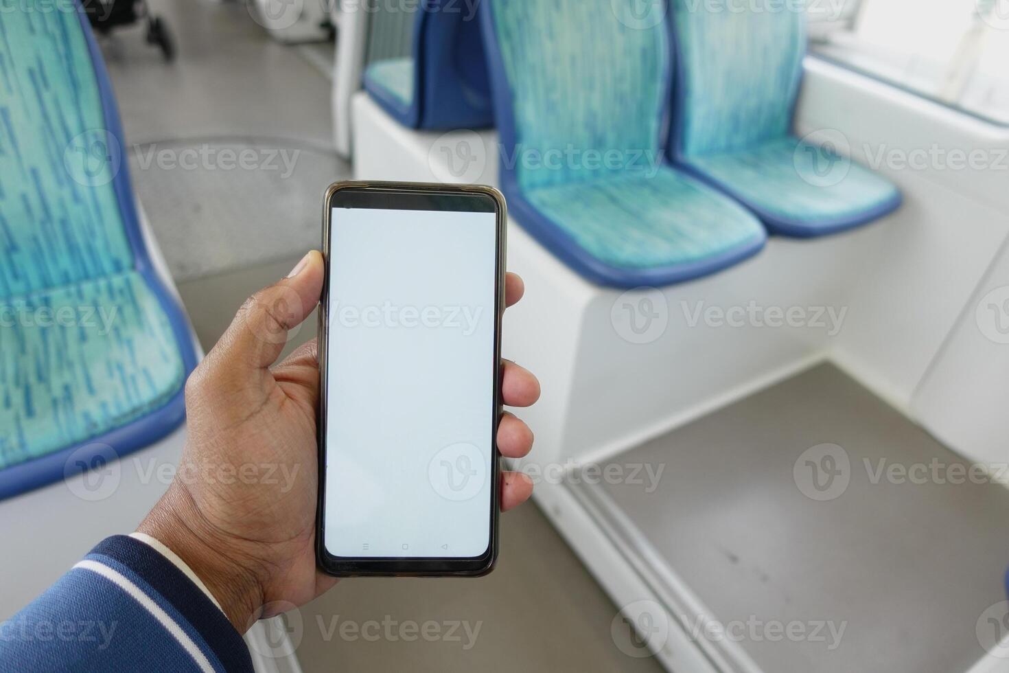young man hand using smart phone with white screen inside of metro train photo
