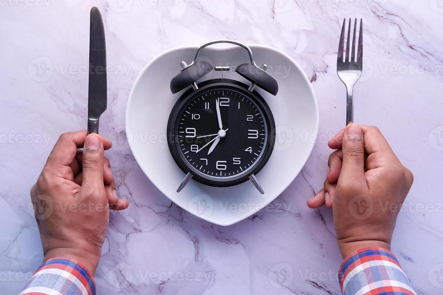 high angle view of clock on plate on wooden table. photo