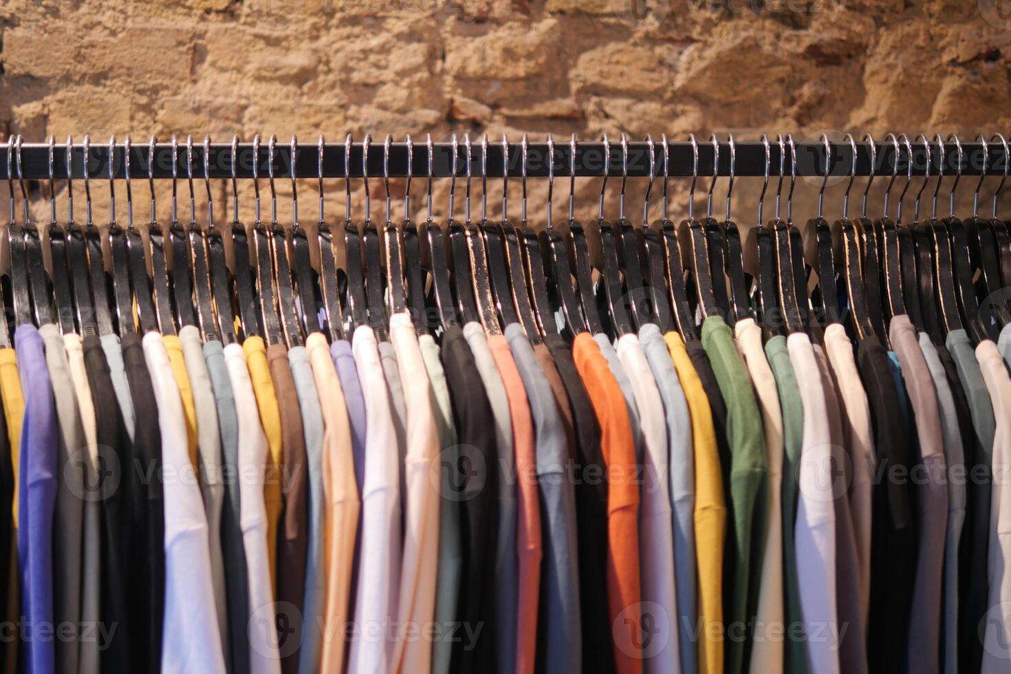 Colorful shirts displayed neatly on rack in clothing store, creating stylish assortment photo