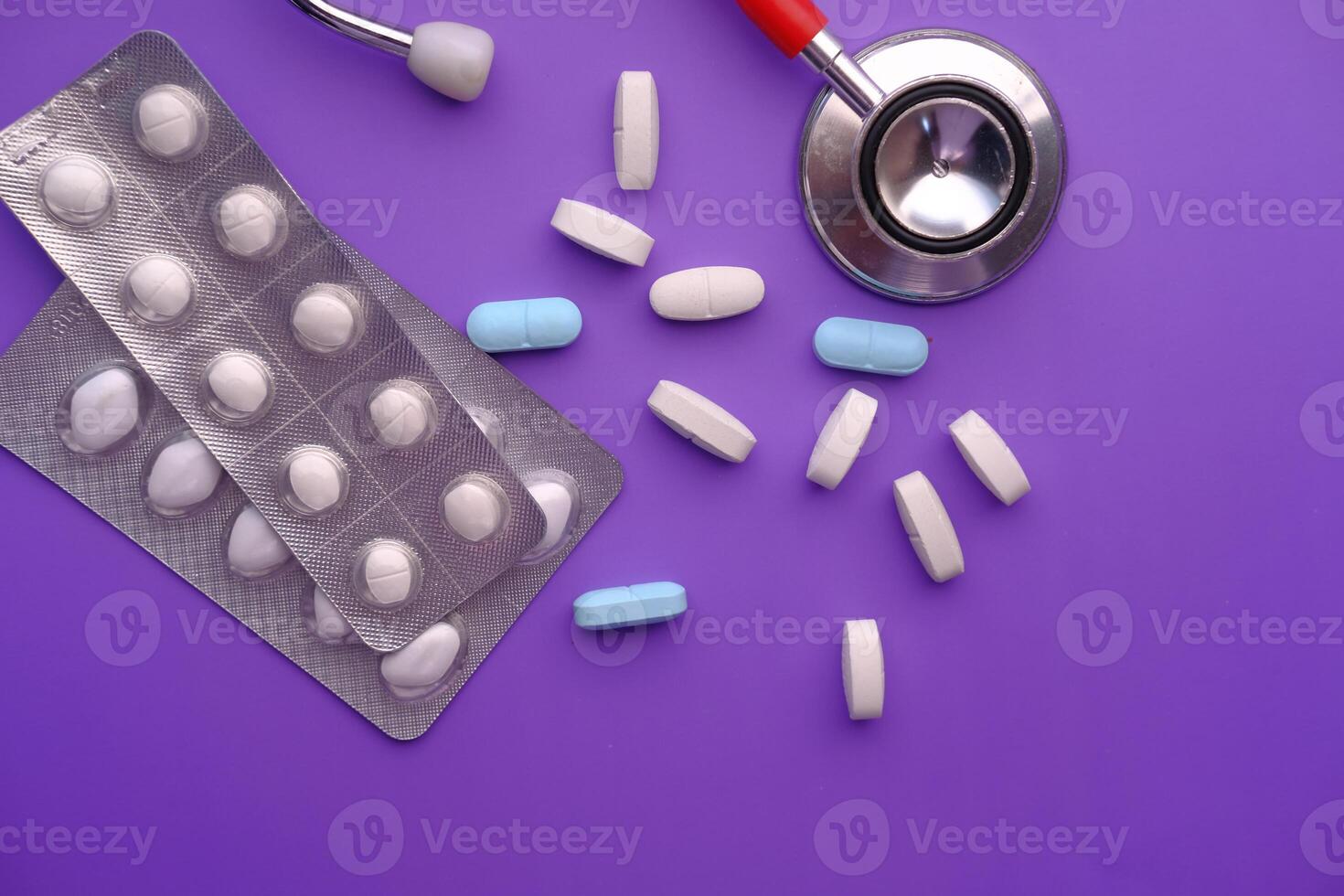 high angle view of white pills , blister pack and stethoscope photo