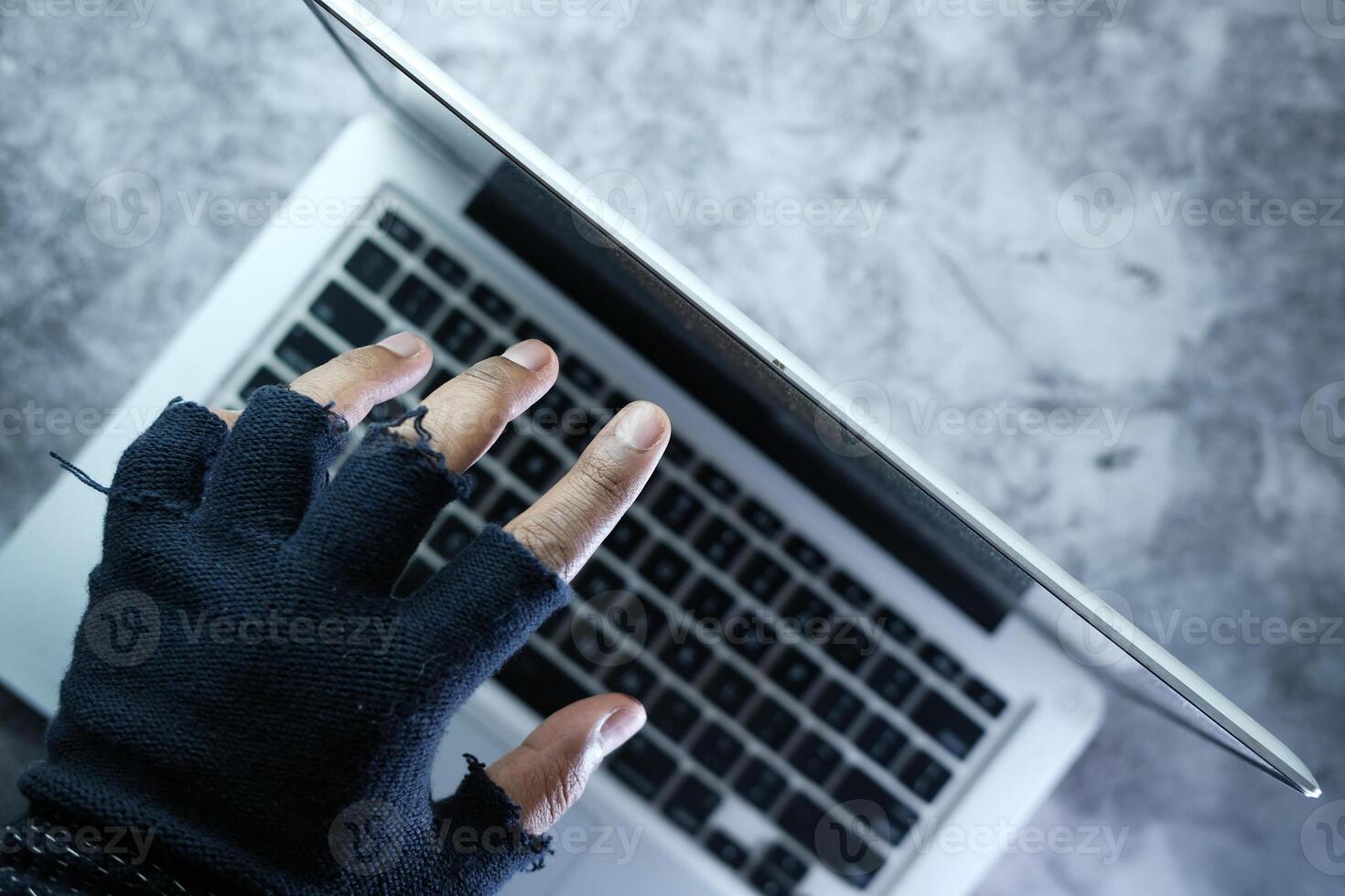 Close up of hacker hand stealing data from laptop photo