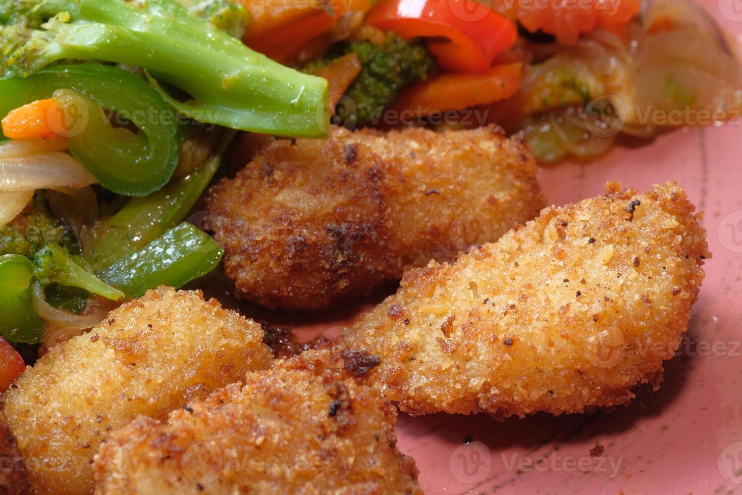 Fried chicken nuggets and salad on plate . photo