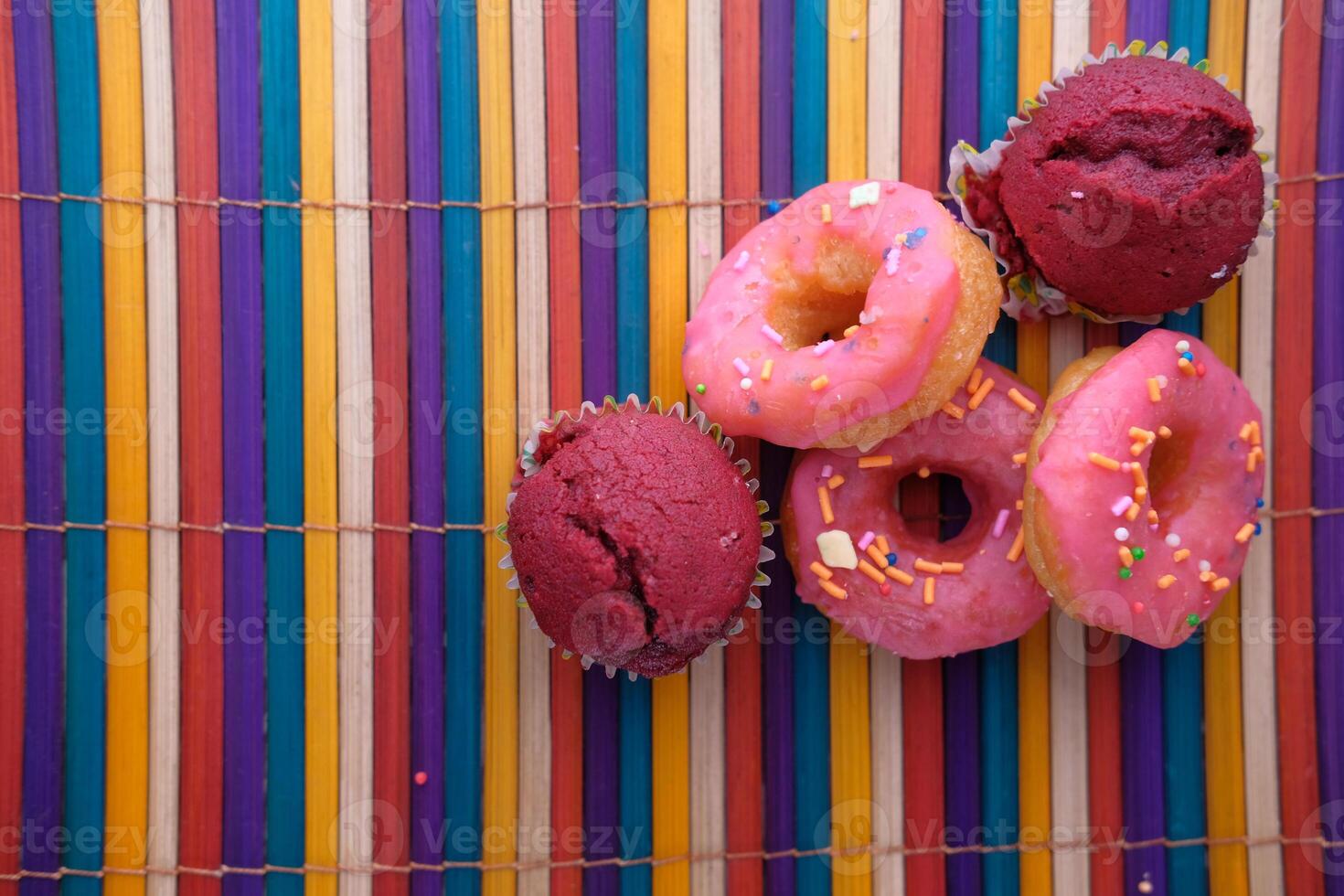 Close up of colorful donuts on wooden table. photo