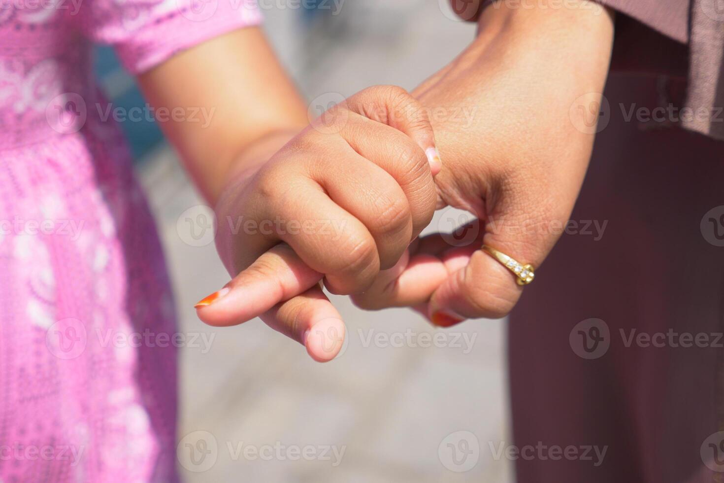 mother holding hand of little girl photo