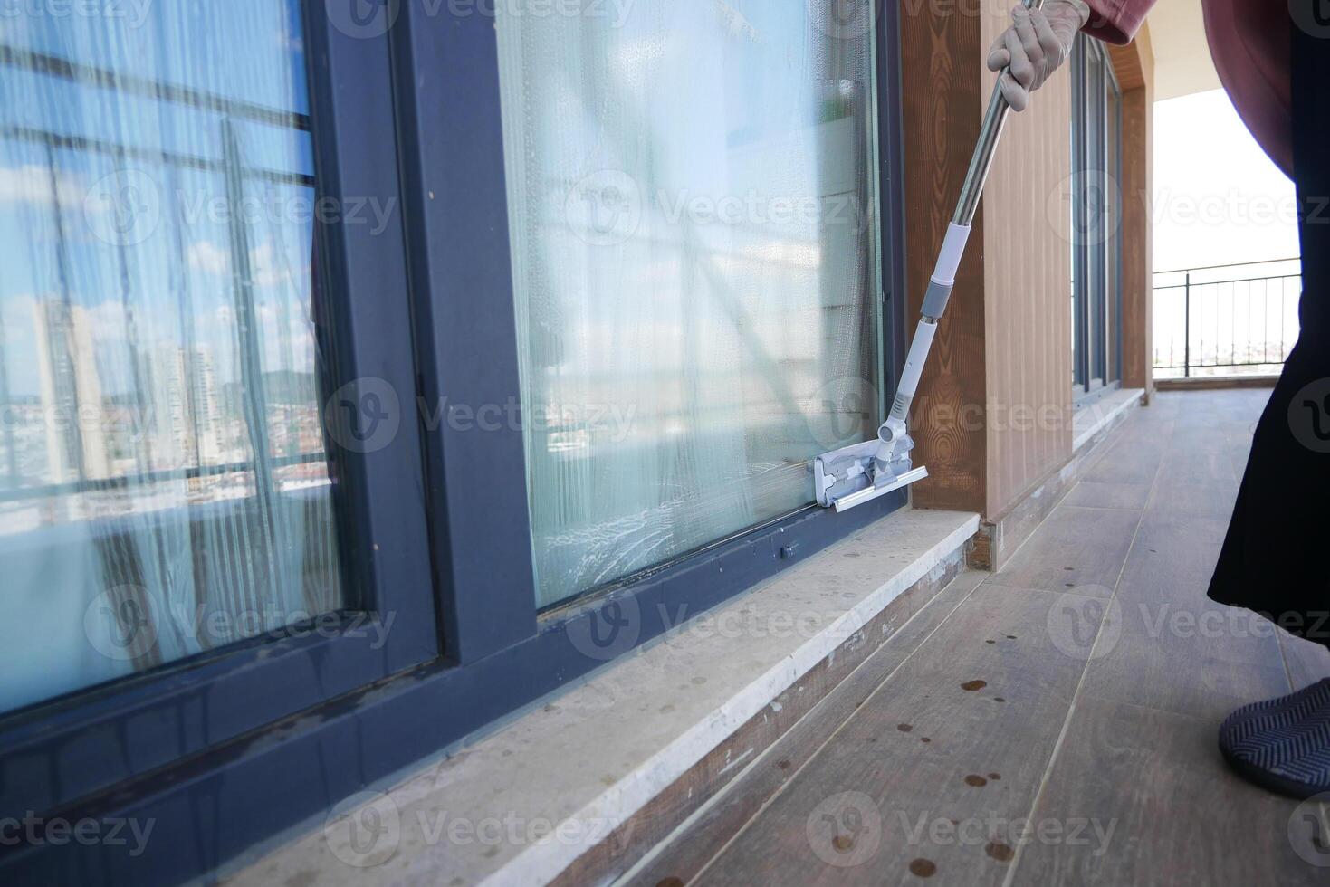 Rubber squeegee cleans a soaped window. photo