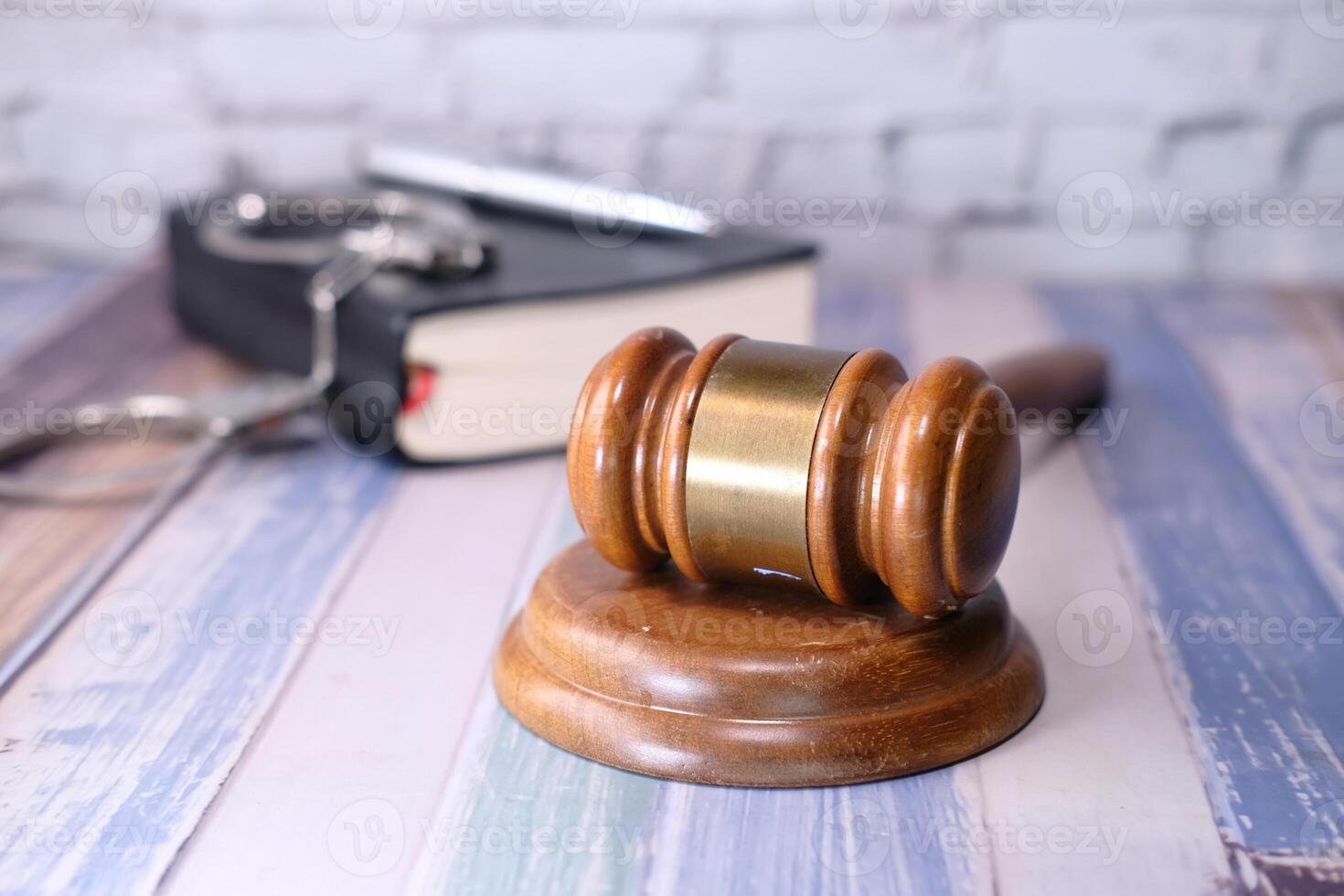 Close up of gavel, book and handcuff on table photo