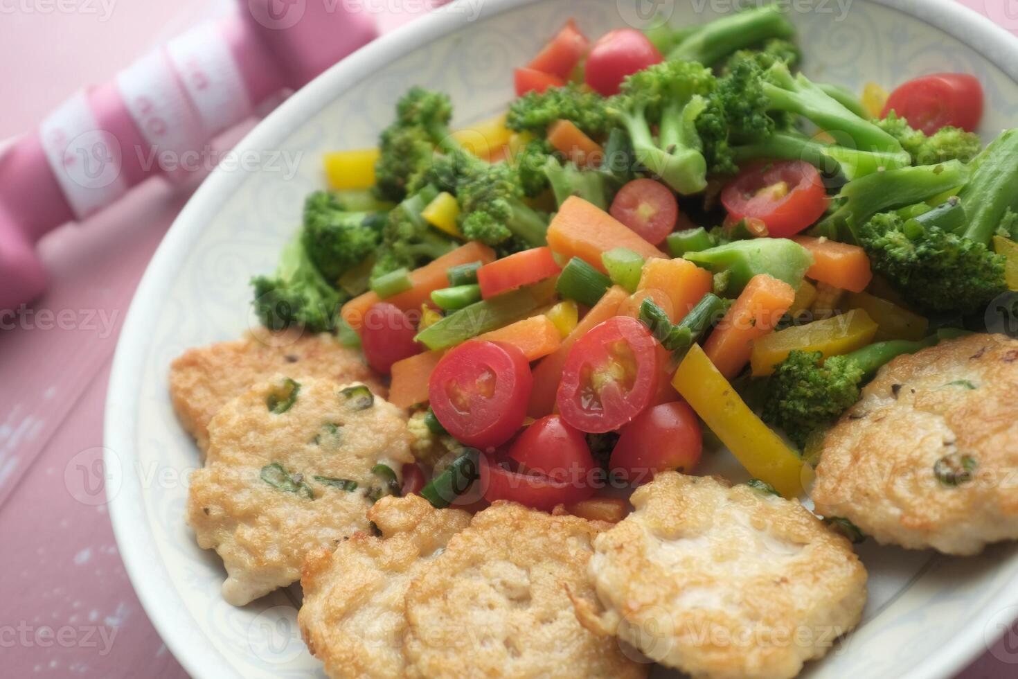 Fried chicken nuggets and salad on plate . photo