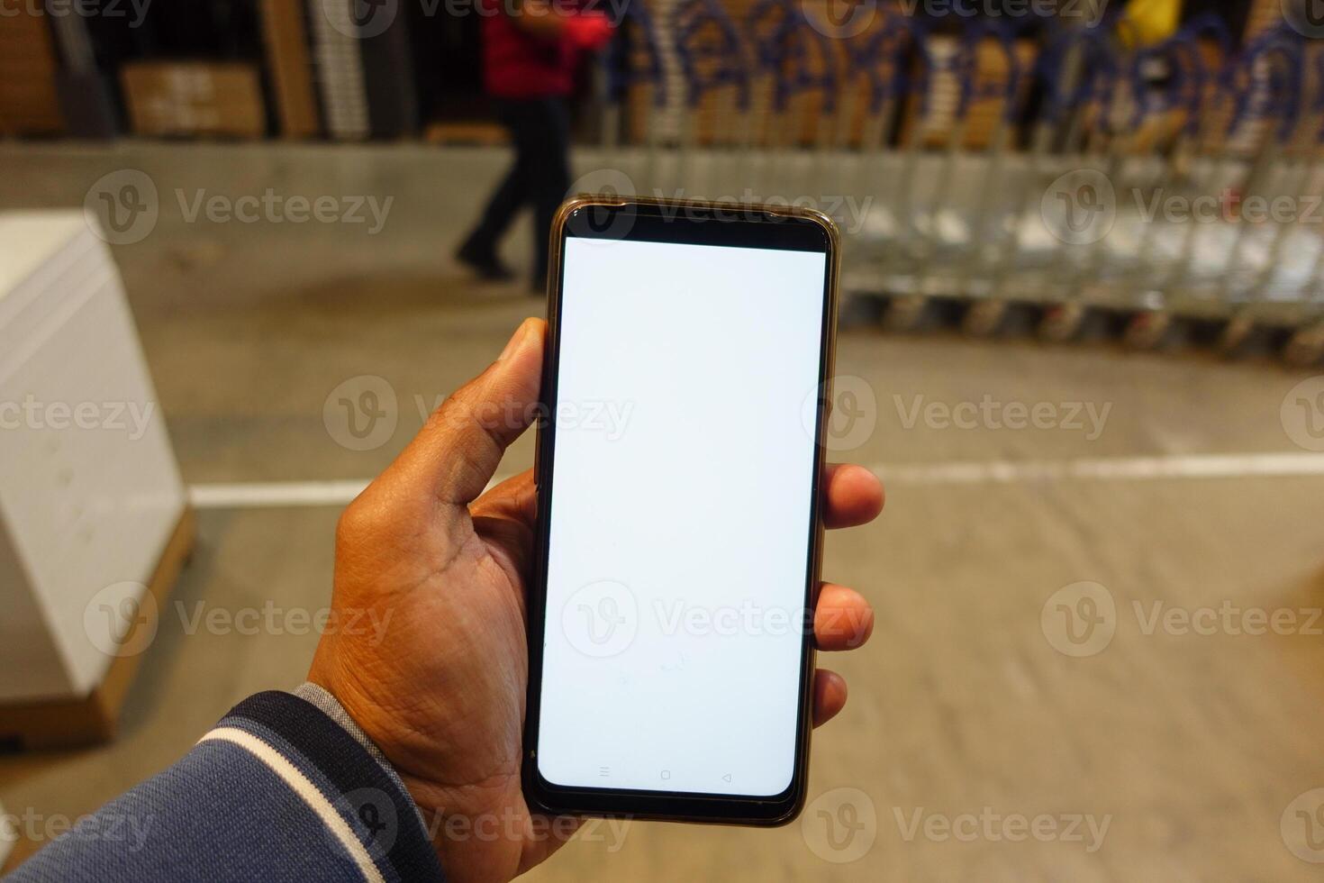 business owner holding phone mock up in warehouse. photo