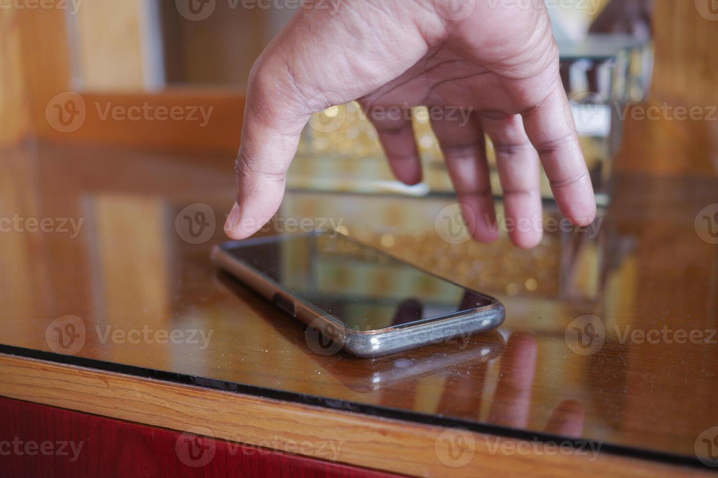 man hand picking up smart phone mobile to receive a call photo