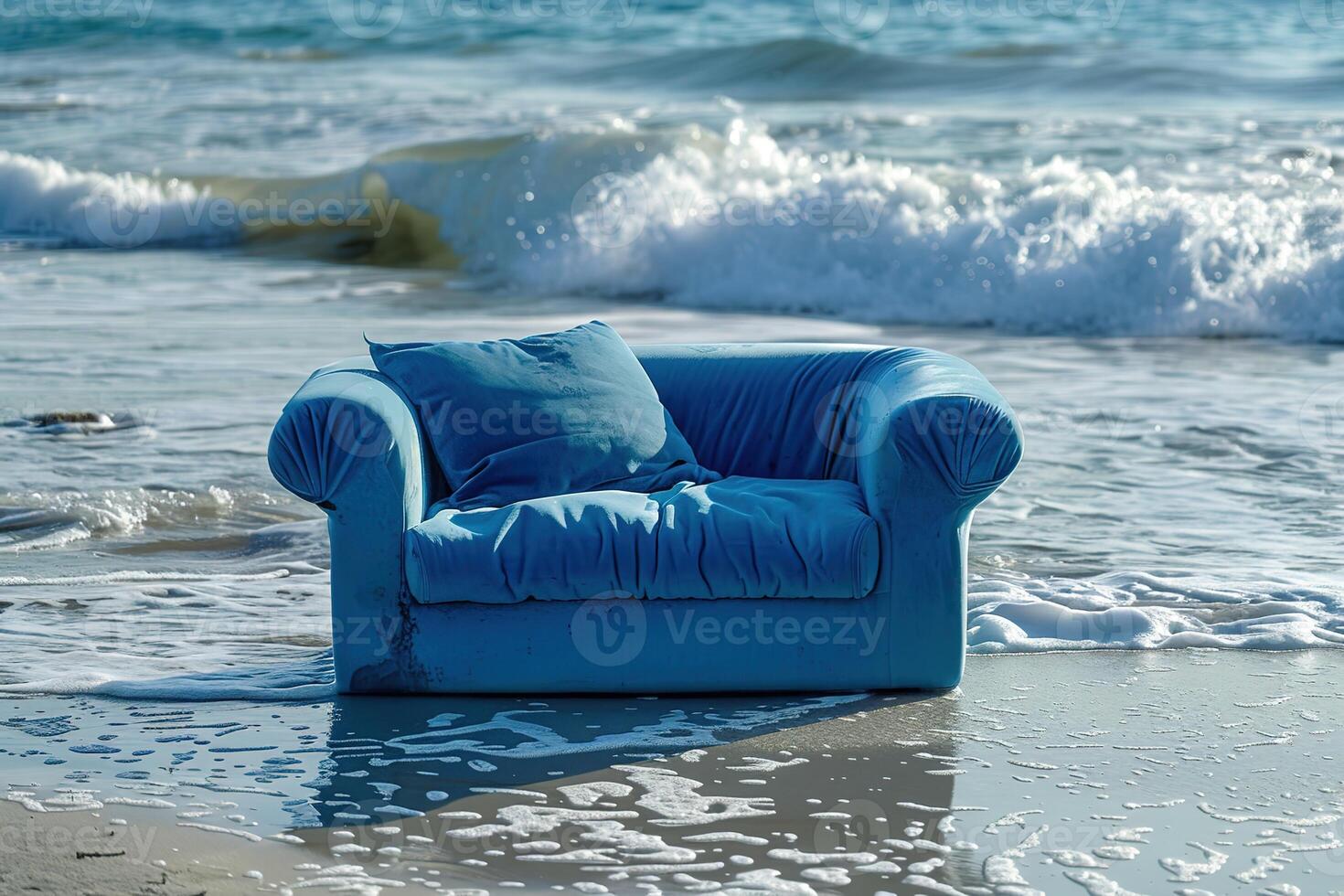 blue sofa stands on the sandy beach on sea photo