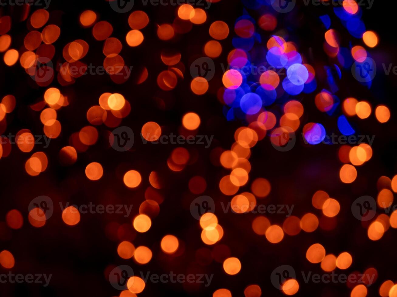 The image is a blurry, colorful background of orange and blue lights photo