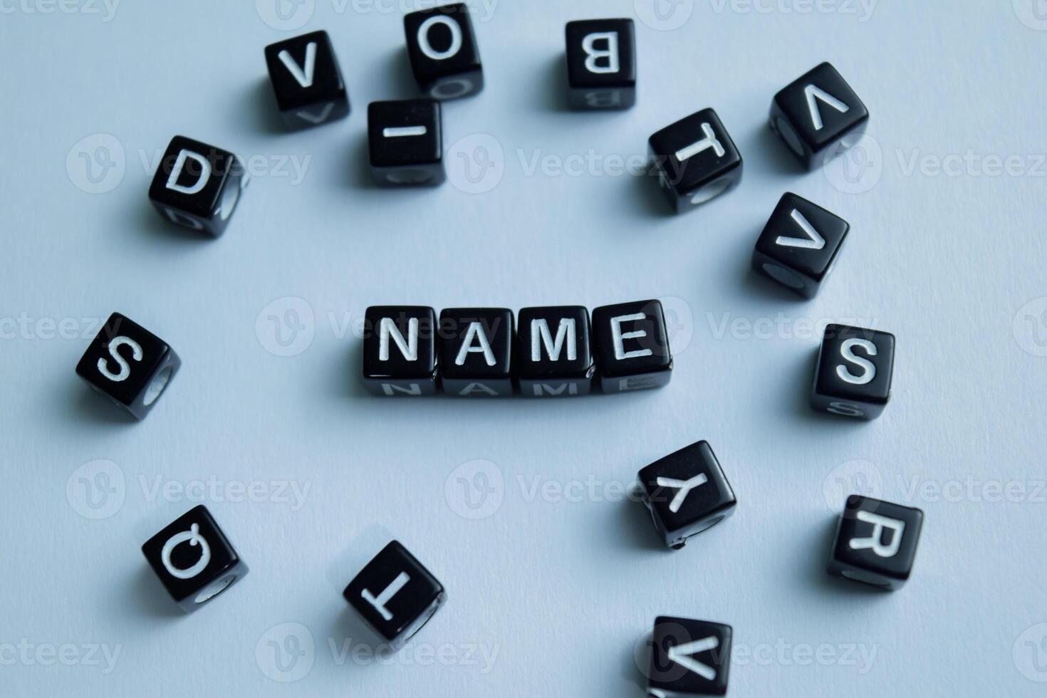 Concept of Name written on wooden blocks. Cross processed image on Wooden Background photo