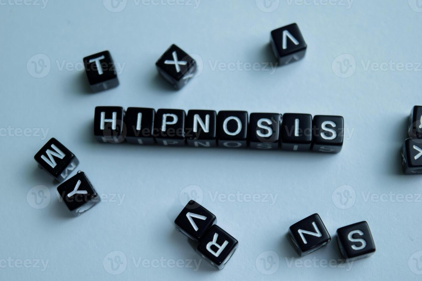 Concept of Hipnosis written on wooden blocks. Cross processed image on Wooden Background photo