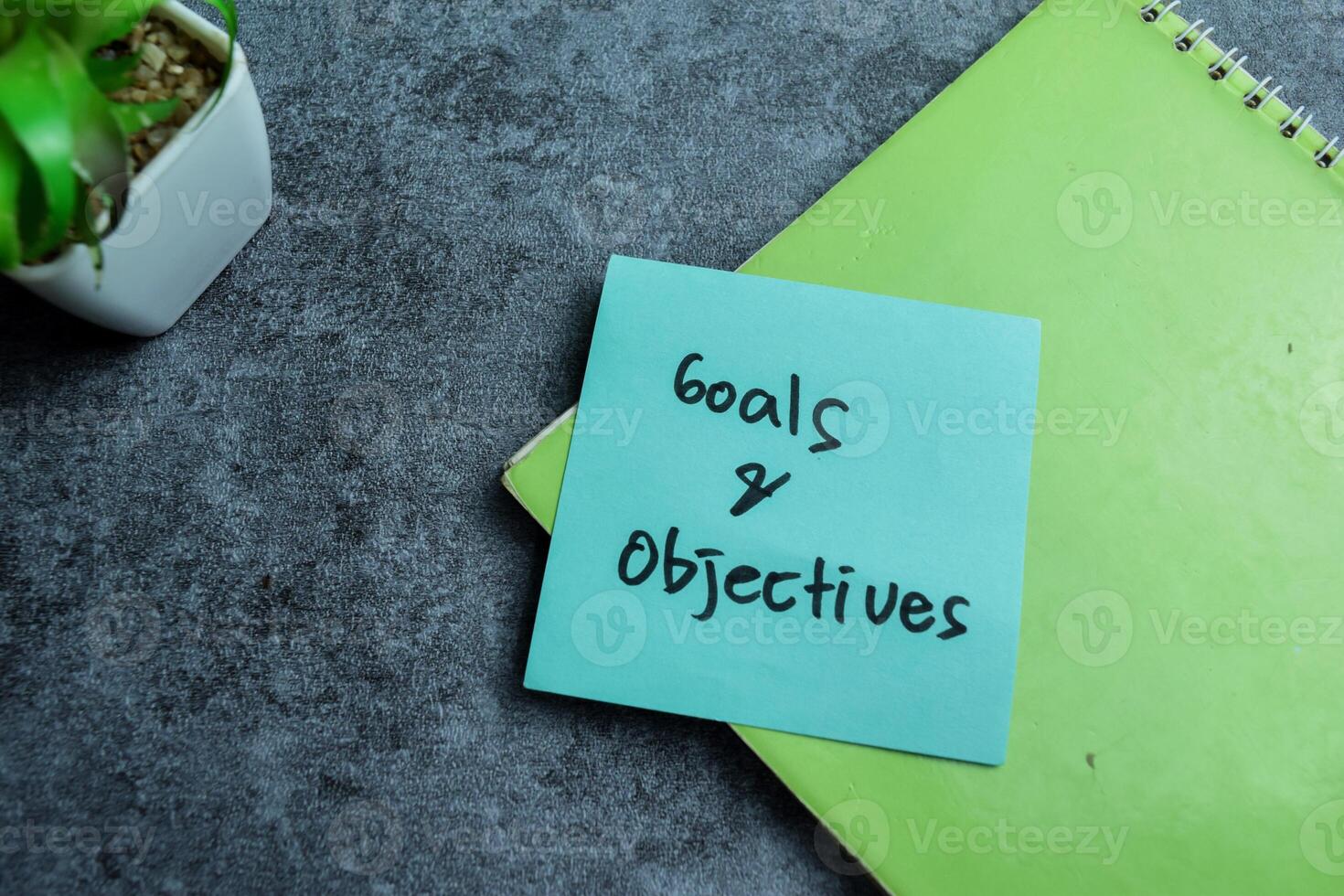 Concept of Goals and Objectives write on sticky notes isolated on Wooden Table. photo