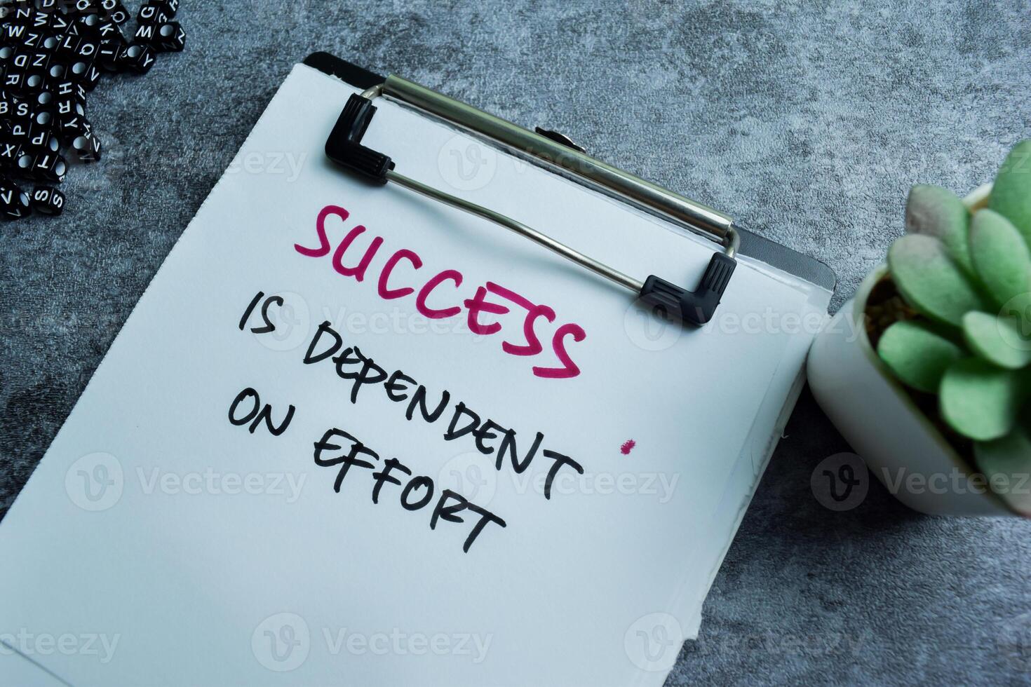 Concept of Success is Dependent on Effort write on paperwork isolated on wooden background. photo