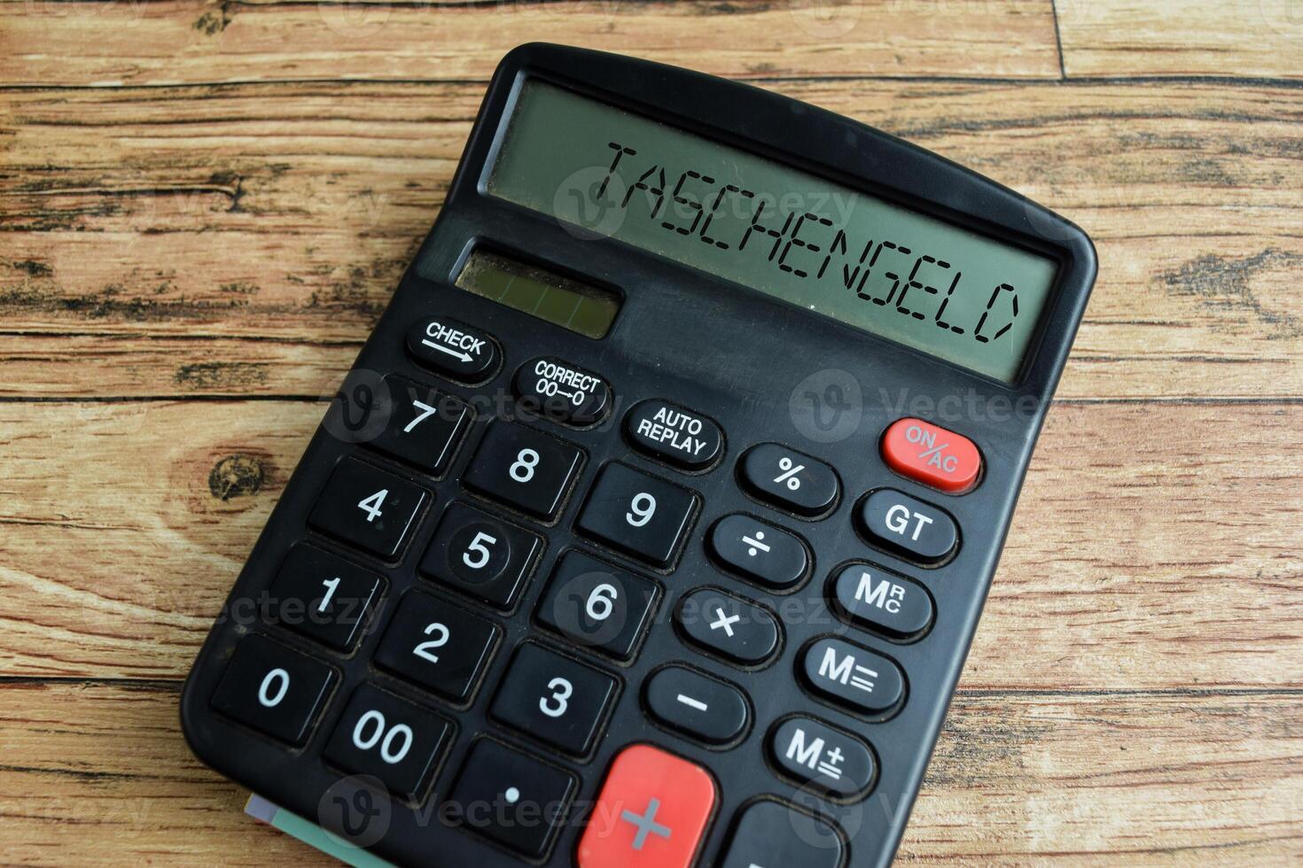 Concept of Learning language - German. Taschengeld it means pocket money written on Calculator. German language isolated on Wooden Table. photo