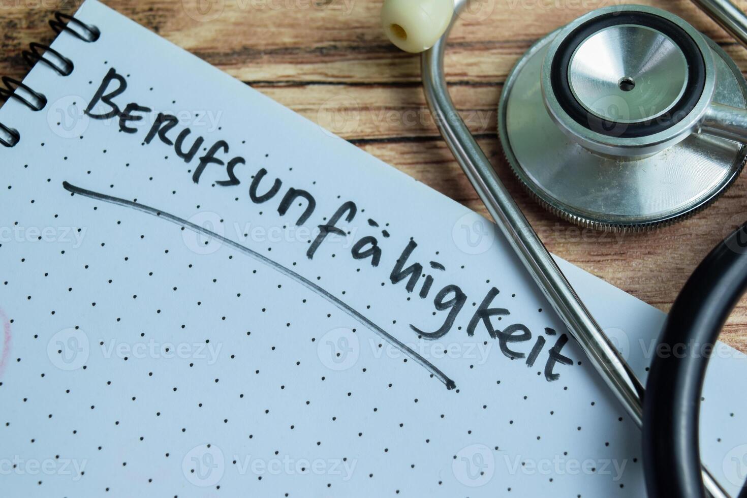 Concept of Learning language - German. Berufsunfahigkeit it means Occupational disability written on book. German language isolated on Wooden Table. photo
