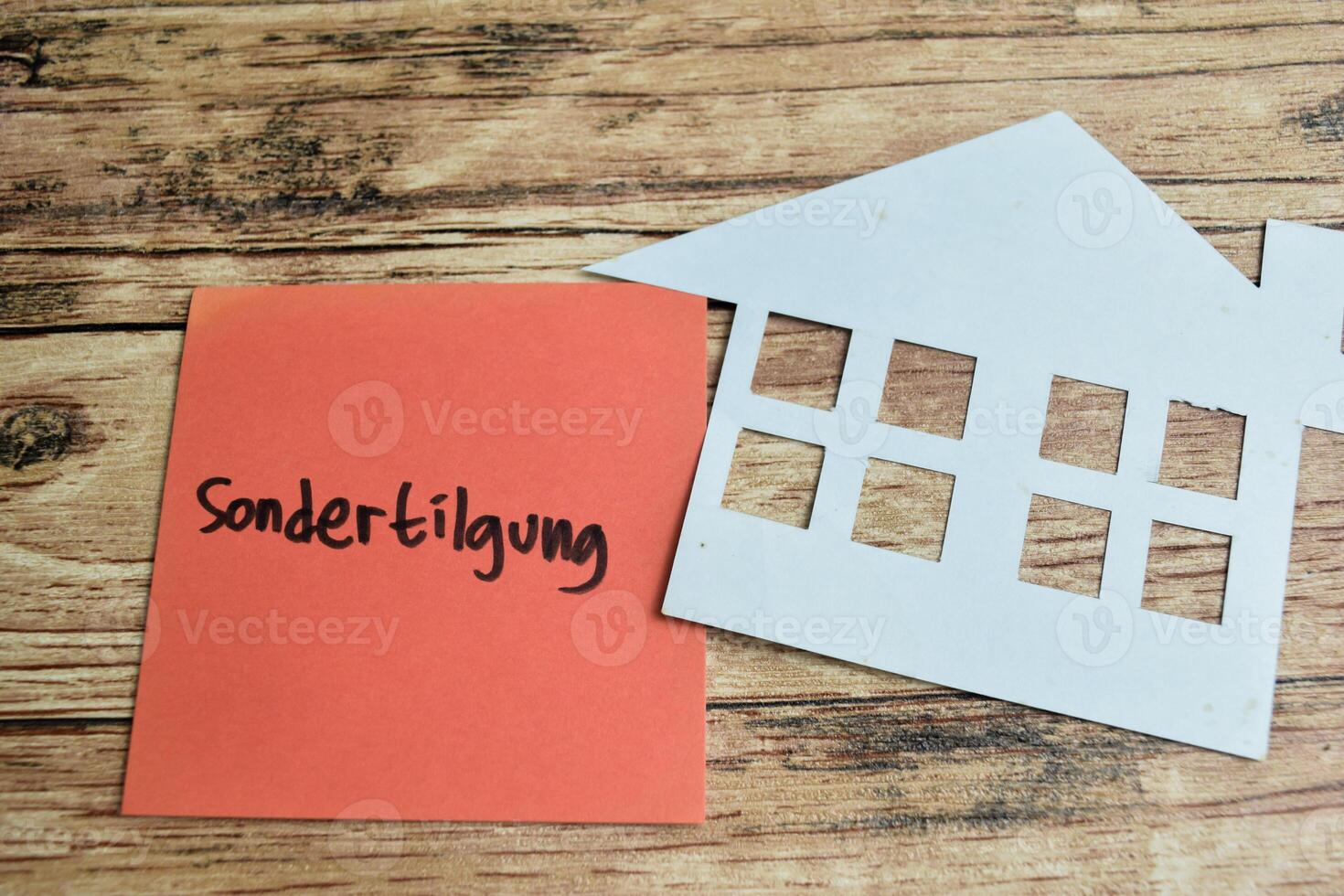 Concept of Learning language - German. Sondertilgung it means Special repayment written on sticky notes. German language isolated on Wooden Table. photo